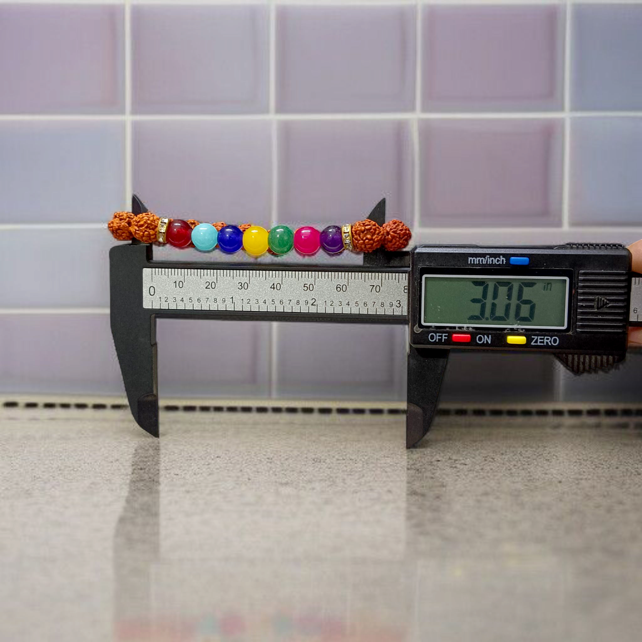 7 Chakra & Rudraksha Bracelet with 8mm natural beads, arranged in colorful chakra order alongside sacred Rudraksha beads, displayed on a spiritual setting