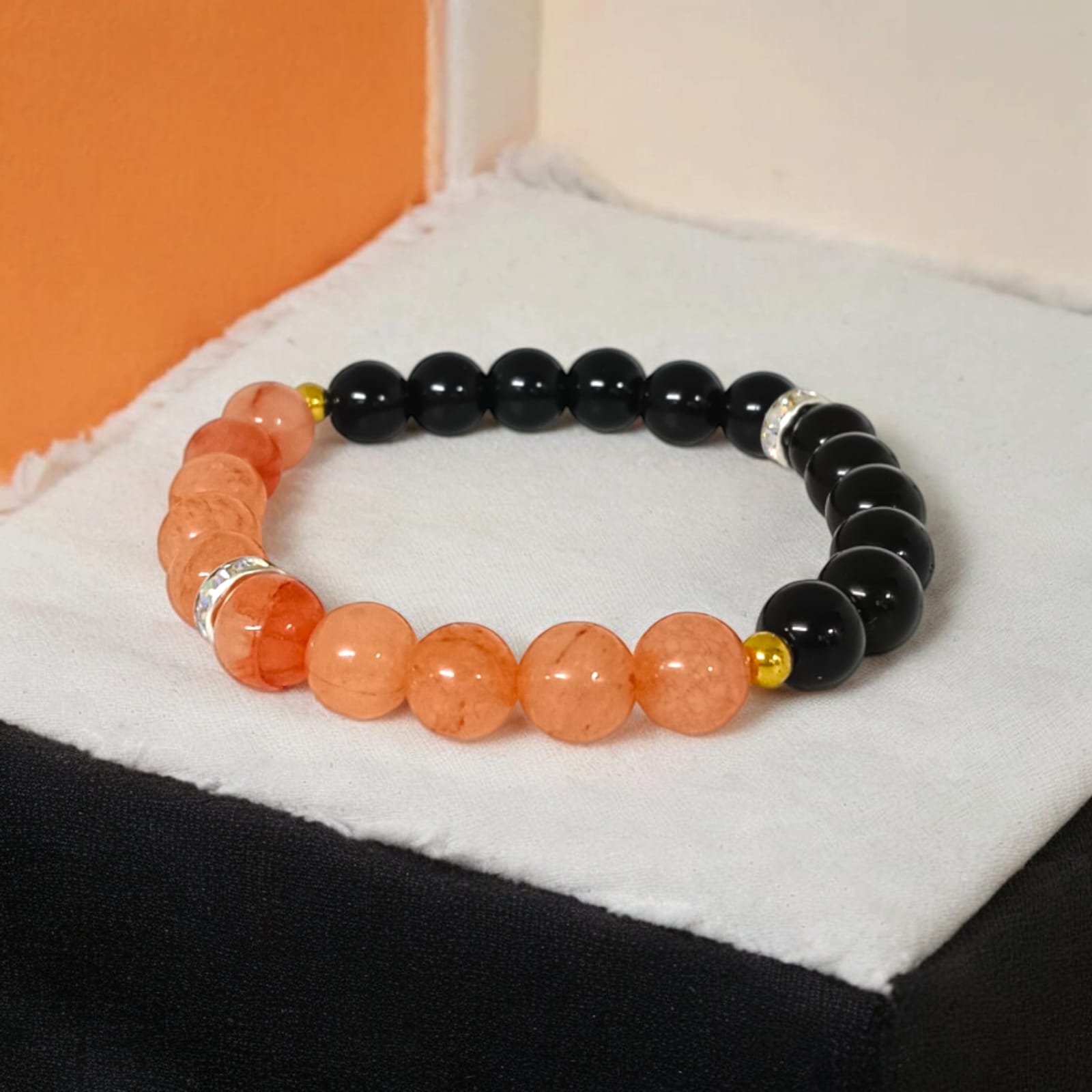 A Hessonite and Black Agate Bracelet with 8MM lab-certified beads, featuring a stretchable design for comfort and spiritual protection.