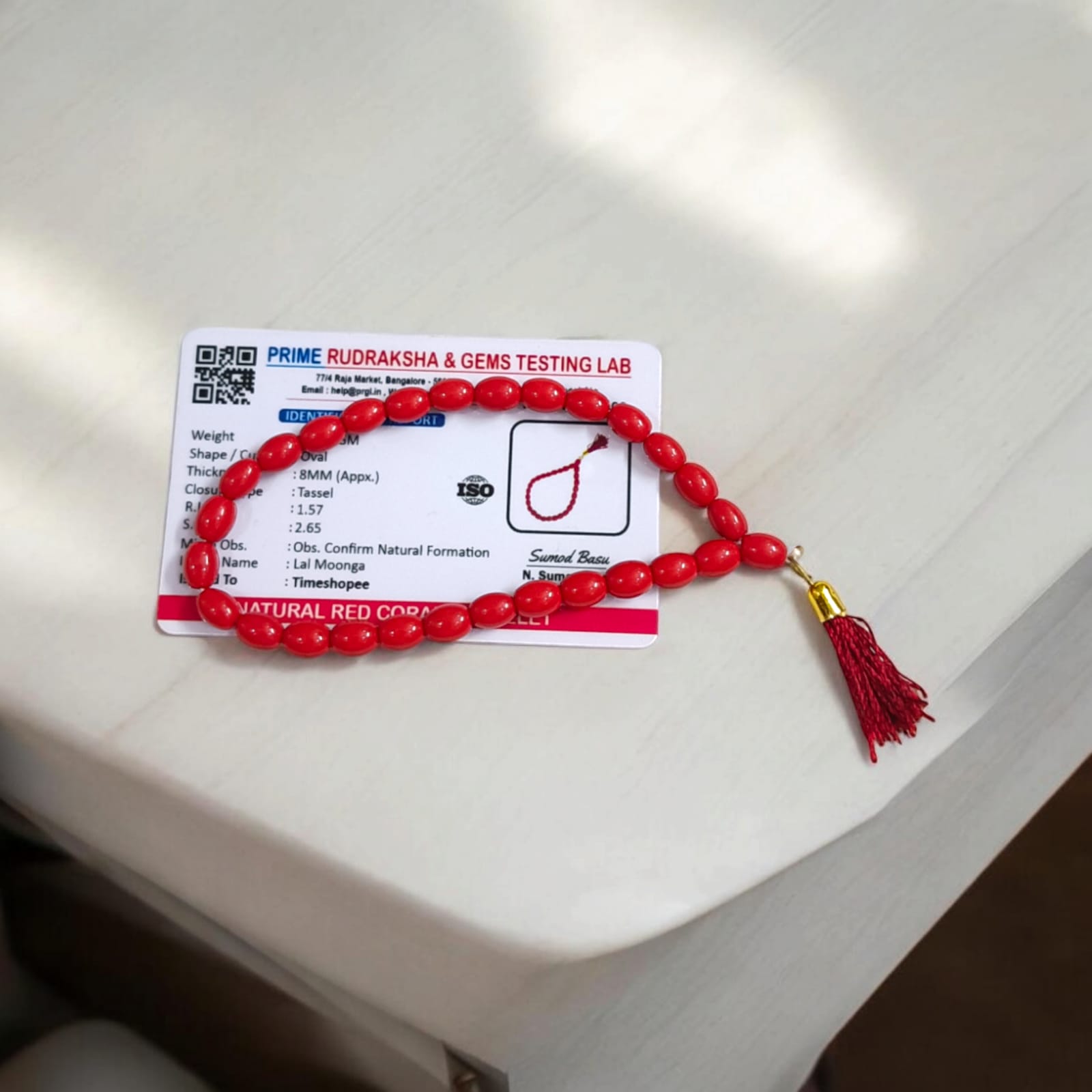 A Lal Moonga Mala featuring 27+1 lab-certified Red Coral beads, each 8MM in size, ideal for car, office, and travel, providing protection and energy balance.