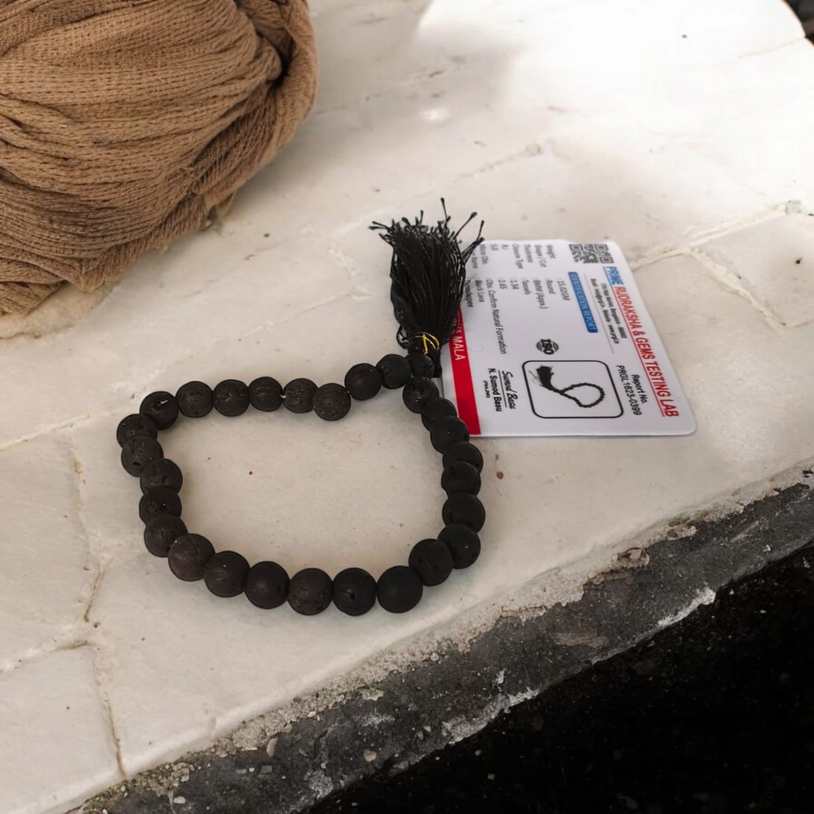 A Natural Lava Mala with 27+1 lab-certified black lava stone beads, each 8MM in size, perfect for grounding energy, meditation, and aromatherapy, suitable for car, office, and travel.