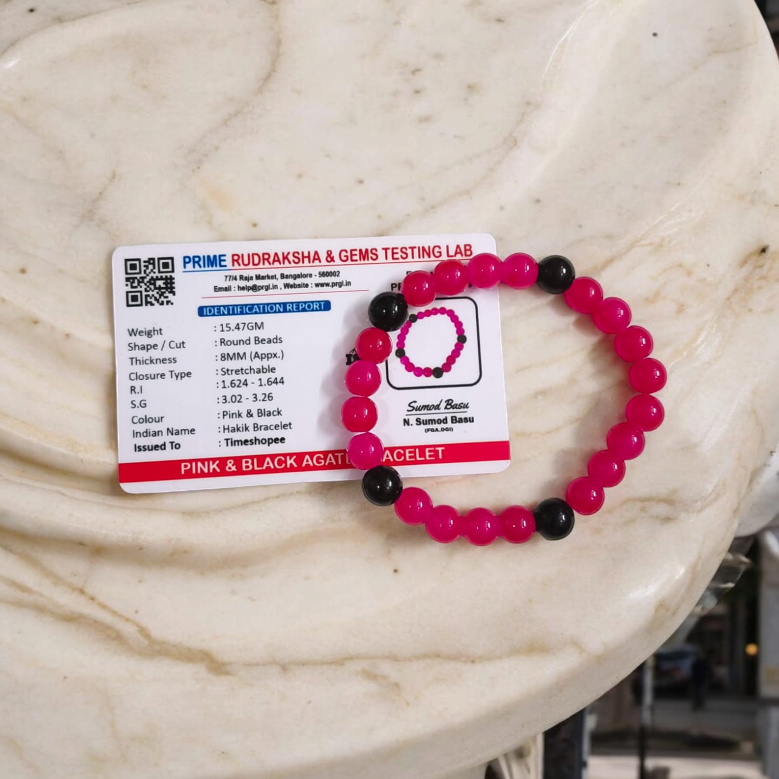 A Pink & Black Agate Bracelet with 8MM lab-certified beads, featuring a stretchable design, ideal for meditation and daily wear.