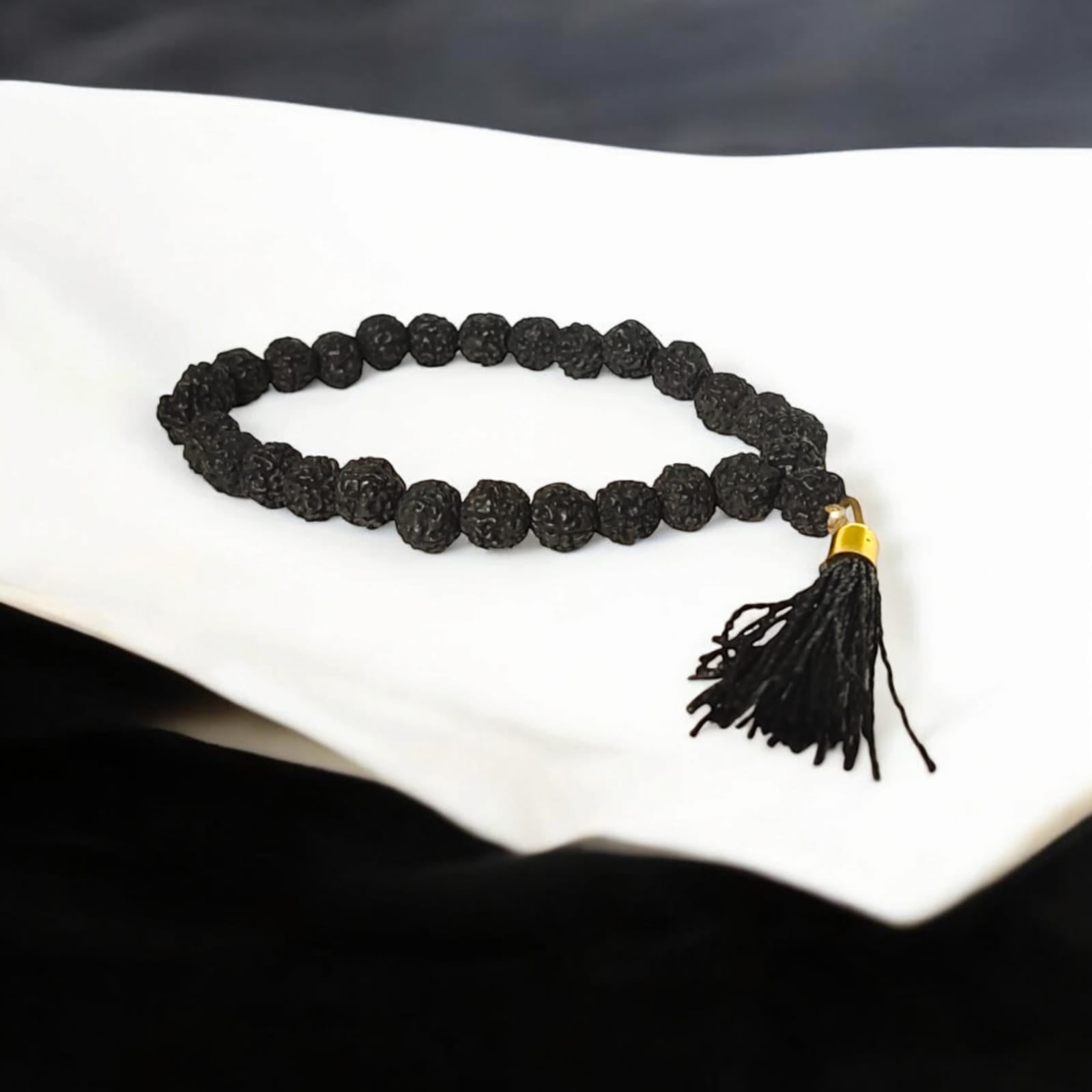 A 27+1 bead Black Rudraksha Mala with 7MM-sized beads, elegantly designed for spiritual use. Suitable for car, office, or travel, the lab-certified beads offer protection and a calming influence.