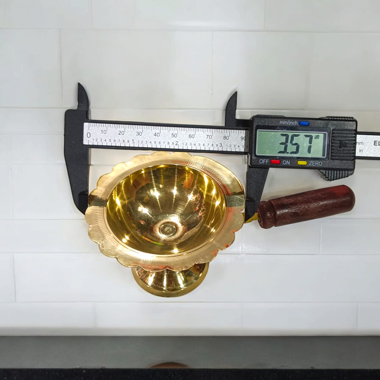 A 4-inch brass Dhooni Dani with a 6-inch wooden handle, used for performing Kapur Aarti, ideal for safe handling during pooja and religious rituals.