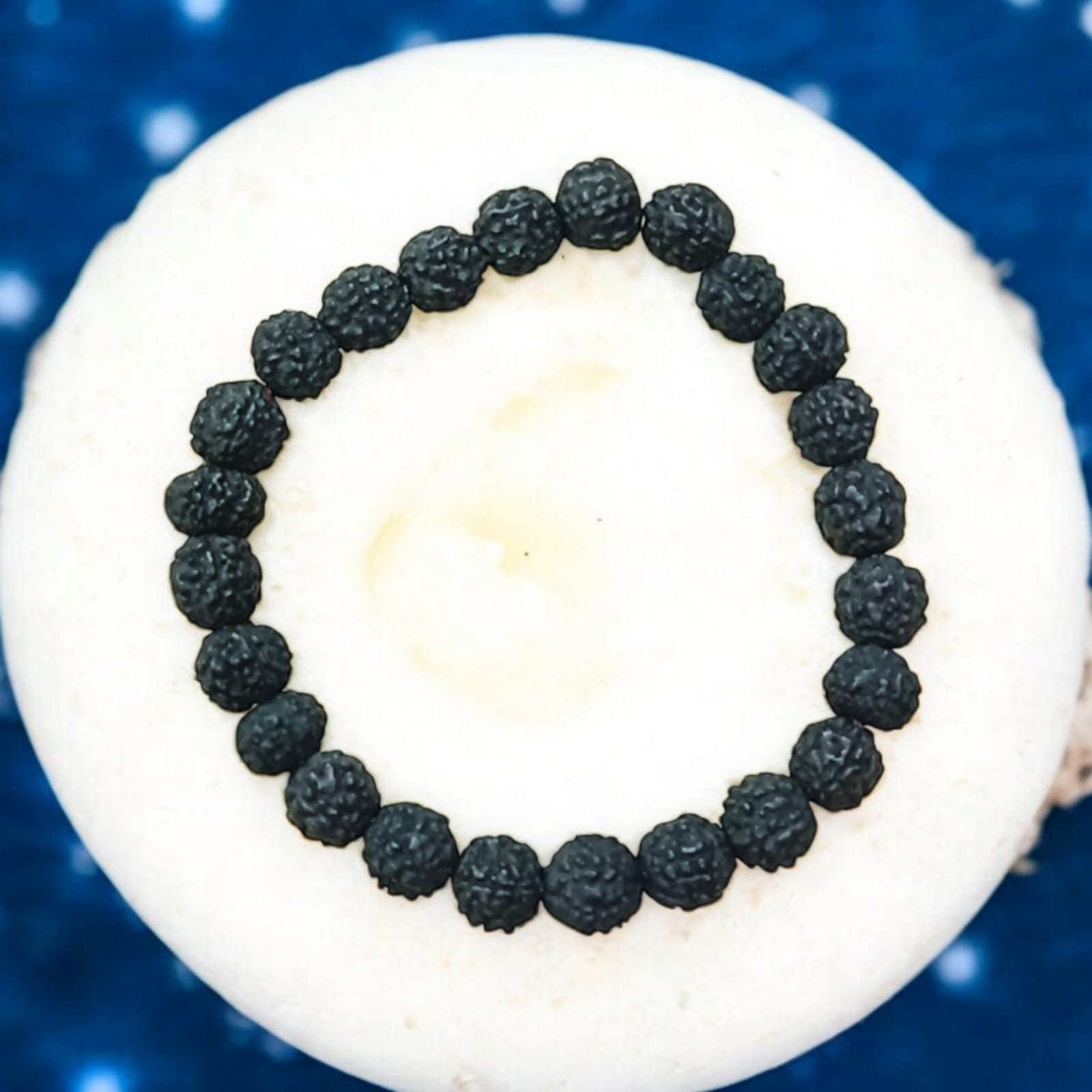A Black Rudraksha Bracelet with 7MM lab-certified beads, elegantly arranged in a stretchable design, perfect for meditation and daily wear.