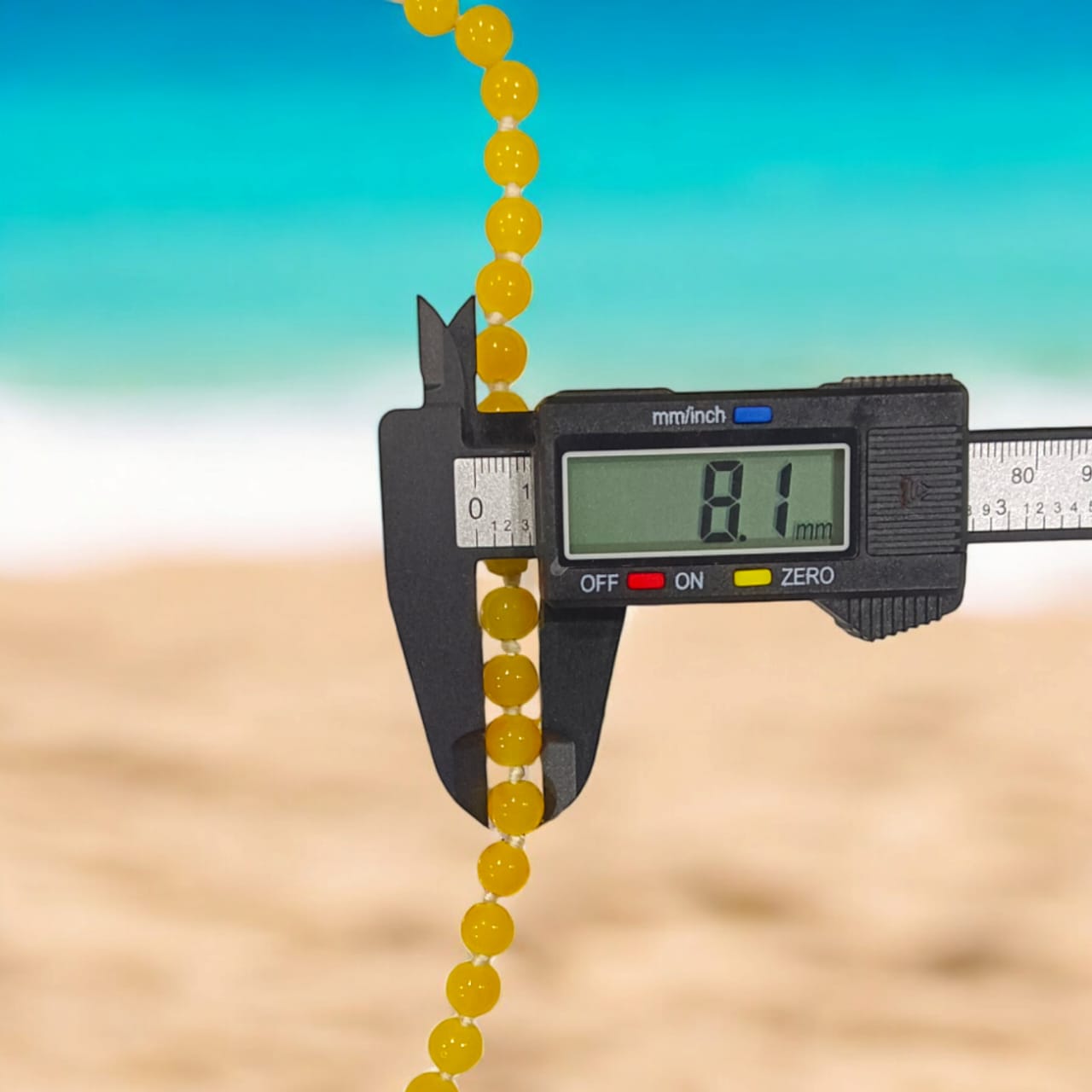 A Yellow Agate Mala with 8MM round beads in 108+1 bead count, hand-threaded and arranged neatly on a white surface, showcasing its golden hue and craftsmanship