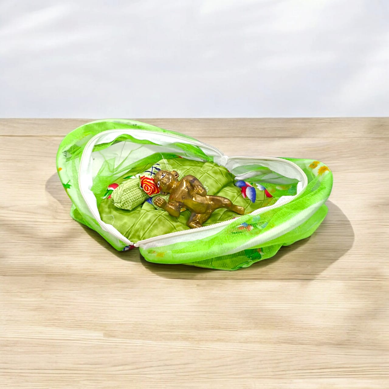 A beautiful 7X10 inch comfortable bed with a mosquito net and three pillows, designed for Laddu Gopal or Radha Rani, available in five vibrant colors for temple use.