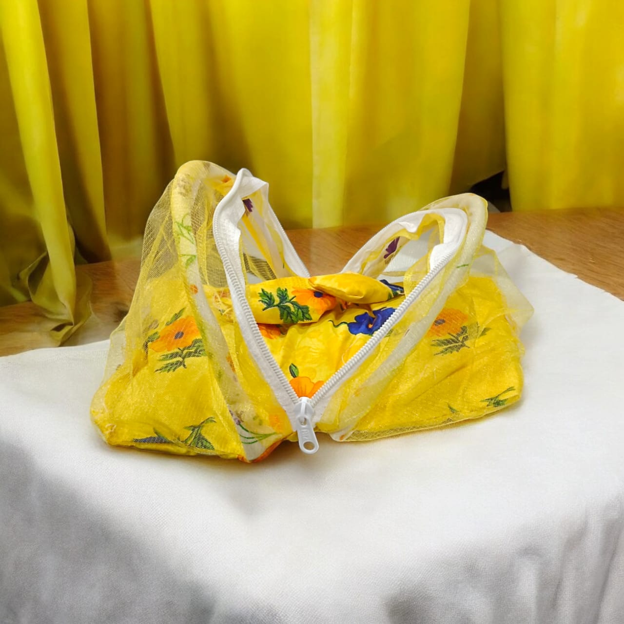 A beautiful 7X10 inch comfortable bed with a mosquito net and three pillows, designed for Laddu Gopal or Radha Rani, available in five vibrant colors for temple use.