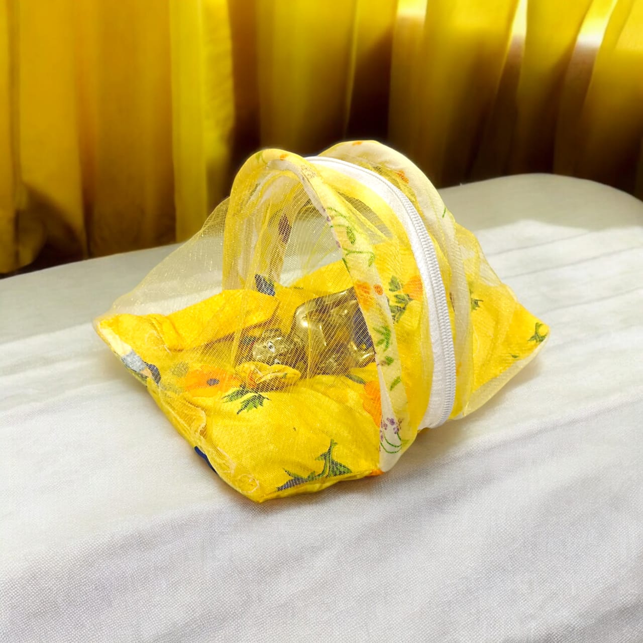 A beautiful 7X10 inch comfortable bed with a mosquito net and three pillows, designed for Laddu Gopal or Radha Rani, available in five vibrant colors for temple use.