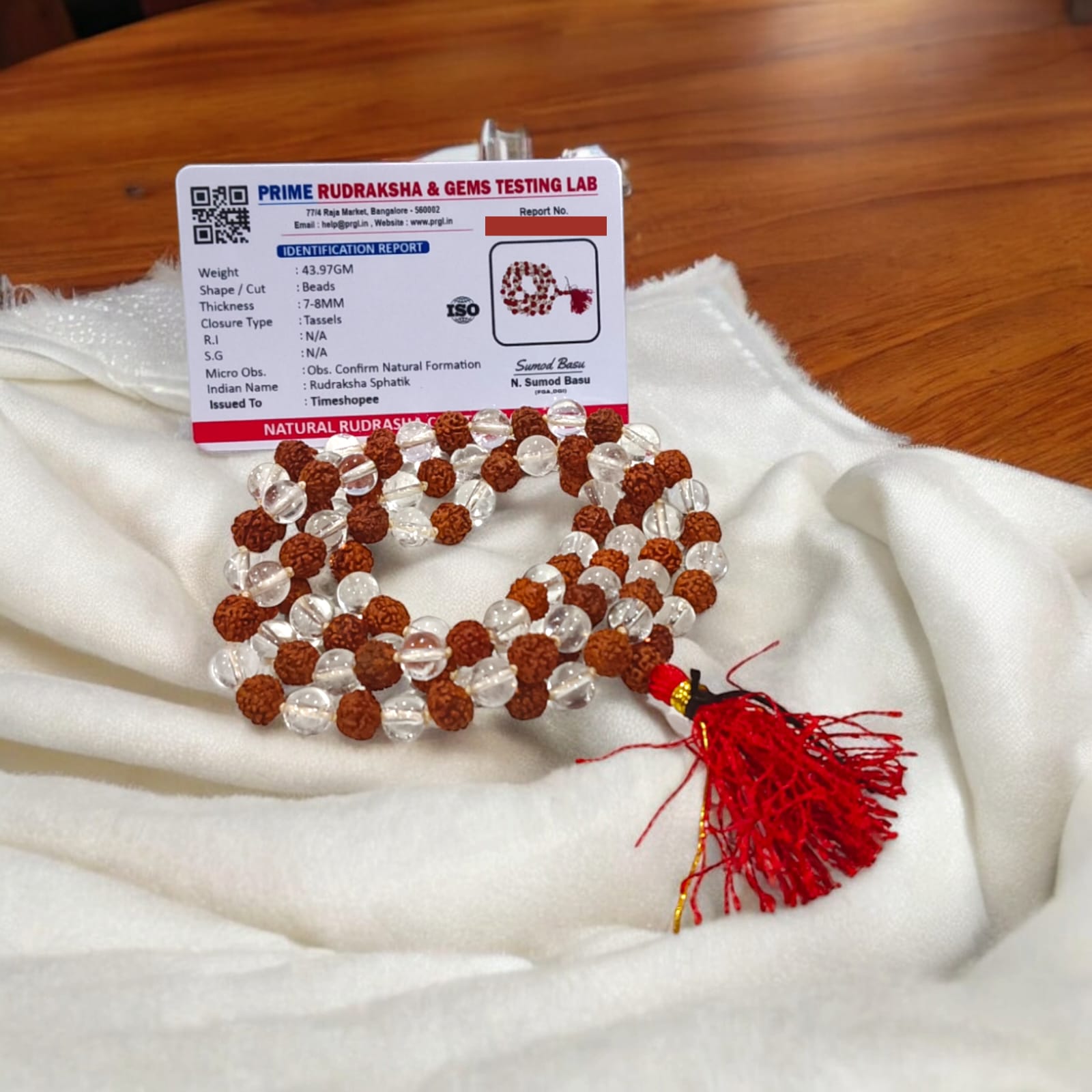 A beautiful Rudraksha and Sphatik Crystal Mala with natural beads, arranged neatly, available in 27+1 and 108+1 variants, displayed on a spiritual-themed background