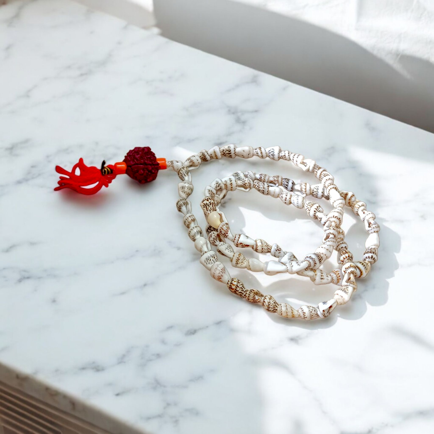 A beautifully handcrafted Shankh Mala (Conch Mala) made from white conch shells, used for meditation and spiritual practices, displayed with certification