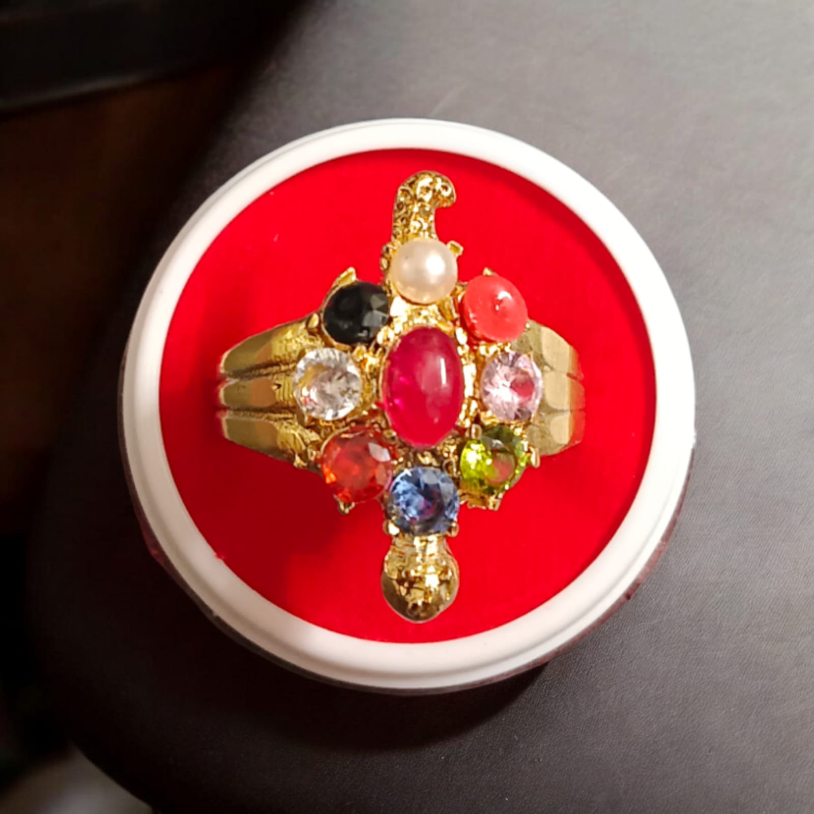 A close-up view of the Navratna Kachua Ring, featuring an array of nine Navratna gemstones set in a gold-plated tortoise-shaped design. The ring is adjustable and suitable for both men and women.