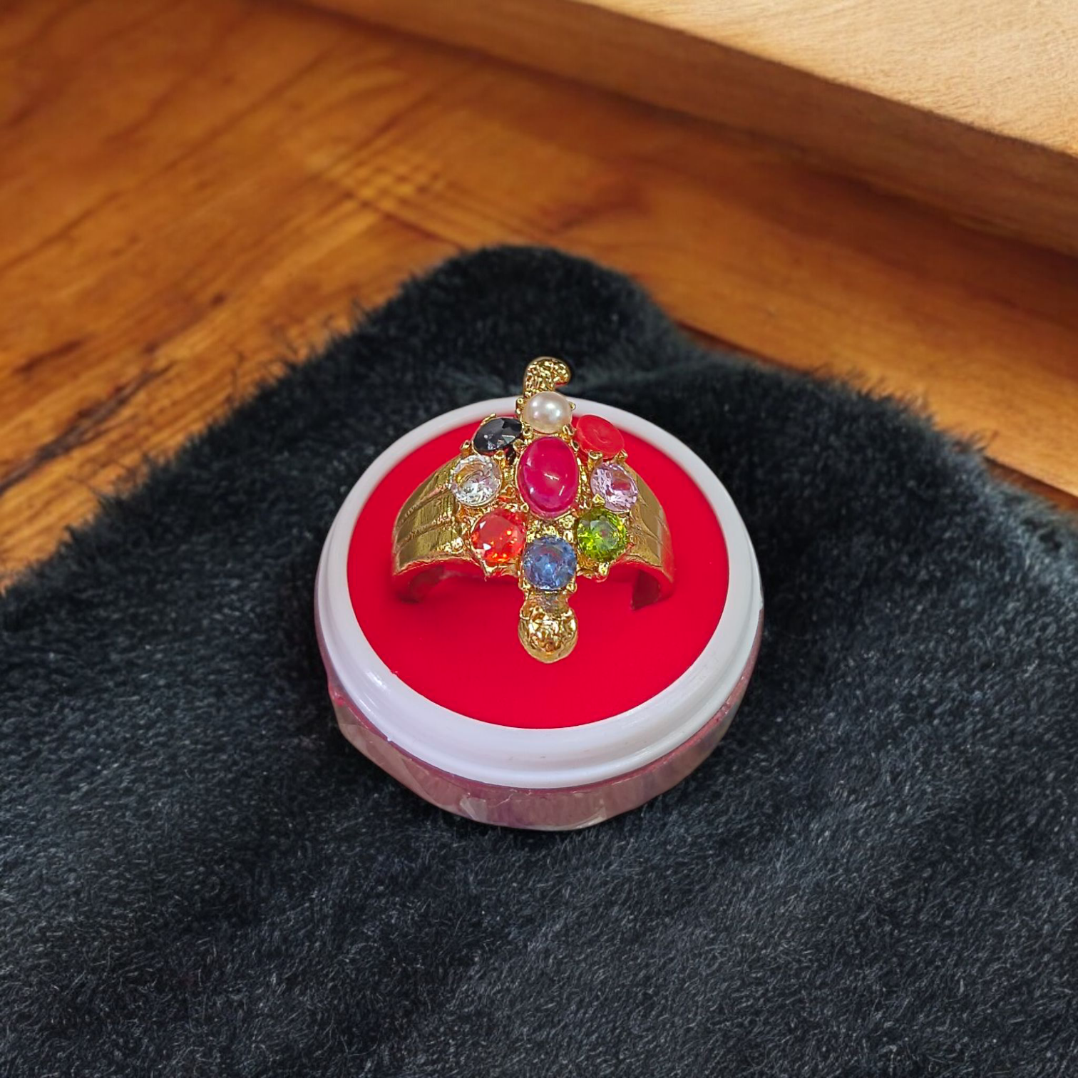 A close-up view of the Navratna Kachua Ring, featuring an array of nine Navratna gemstones set in a gold-plated tortoise-shaped design. The ring is adjustable and suitable for both men and women.