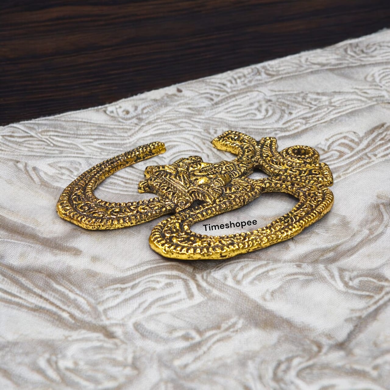 A decorative brass wall hanging featuring the sacred Om symbol, measuring 4X5 inches, suitable for temples, offices, and home walls to promote spirituality.