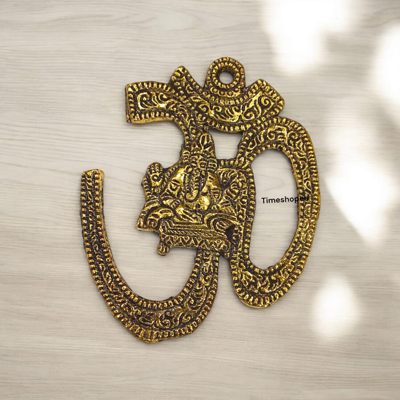 A decorative brass wall hanging featuring the sacred Om symbol, measuring 4X5 inches, suitable for temples, offices, and home walls to promote spirituality.