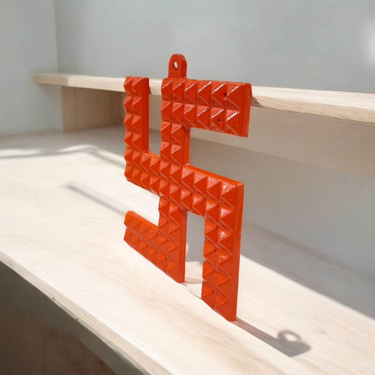 A decorative metal wall hanging featuring a Swastik and 68 Vaastu Pyramid, measuring 10X10 CM, suitable for hanging in temples, offices, and homes to promote positive energy.