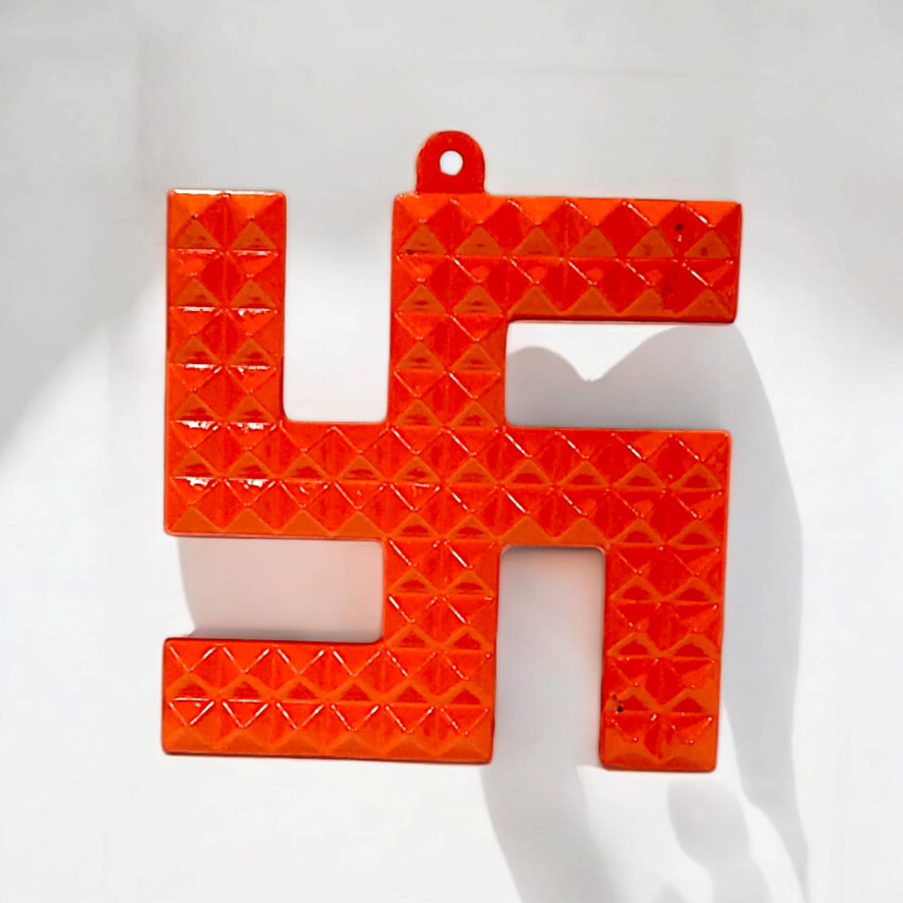 A decorative metal wall hanging featuring a Swastik and 68 Vaastu Pyramid, measuring 10X10 CM, suitable for hanging in temples, offices, and homes to promote positive energy.