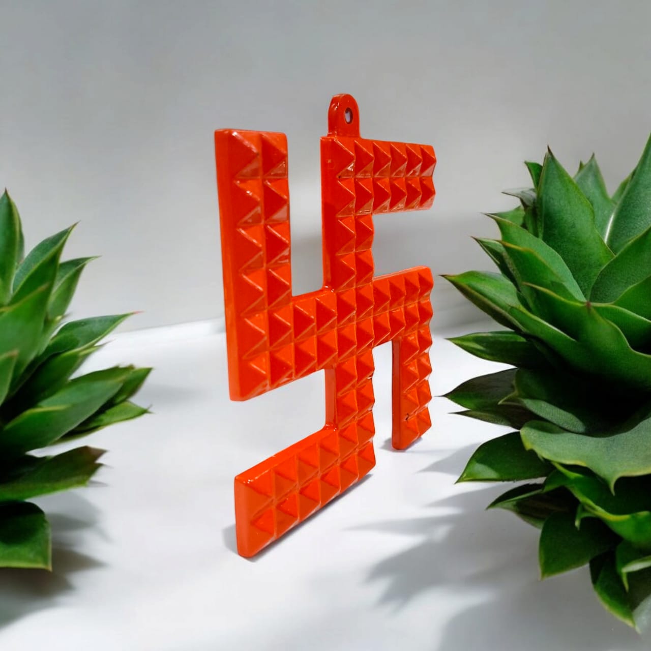 A decorative metal wall hanging featuring a Swastik and 68 Vaastu Pyramid, measuring 10X10 CM, suitable for hanging in temples, offices, and homes to promote positive energy.