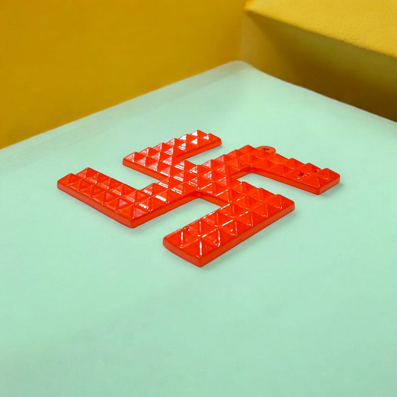 A decorative metal wall hanging featuring a Swastik and 68 Vaastu Pyramid, measuring 10X10 CM, suitable for hanging in temples, offices, and homes to promote positive energy.