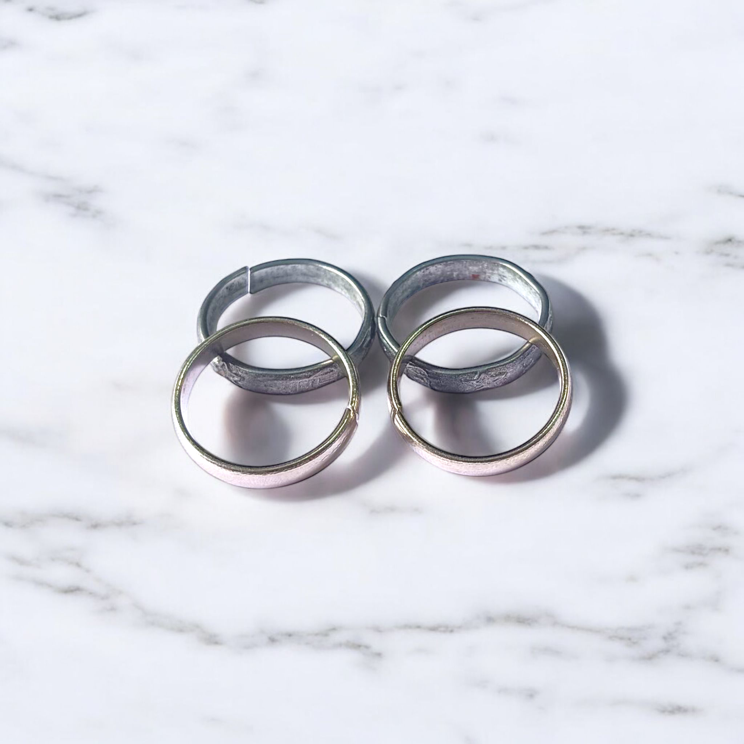 A set of four Ghode Ki Naal ka Challa rings made from black horse shoe nails, each ring designed to mitigate the negative effects of Saturn (Shani). The rings are shown in a close-up view to highlight their craftsmanship and material