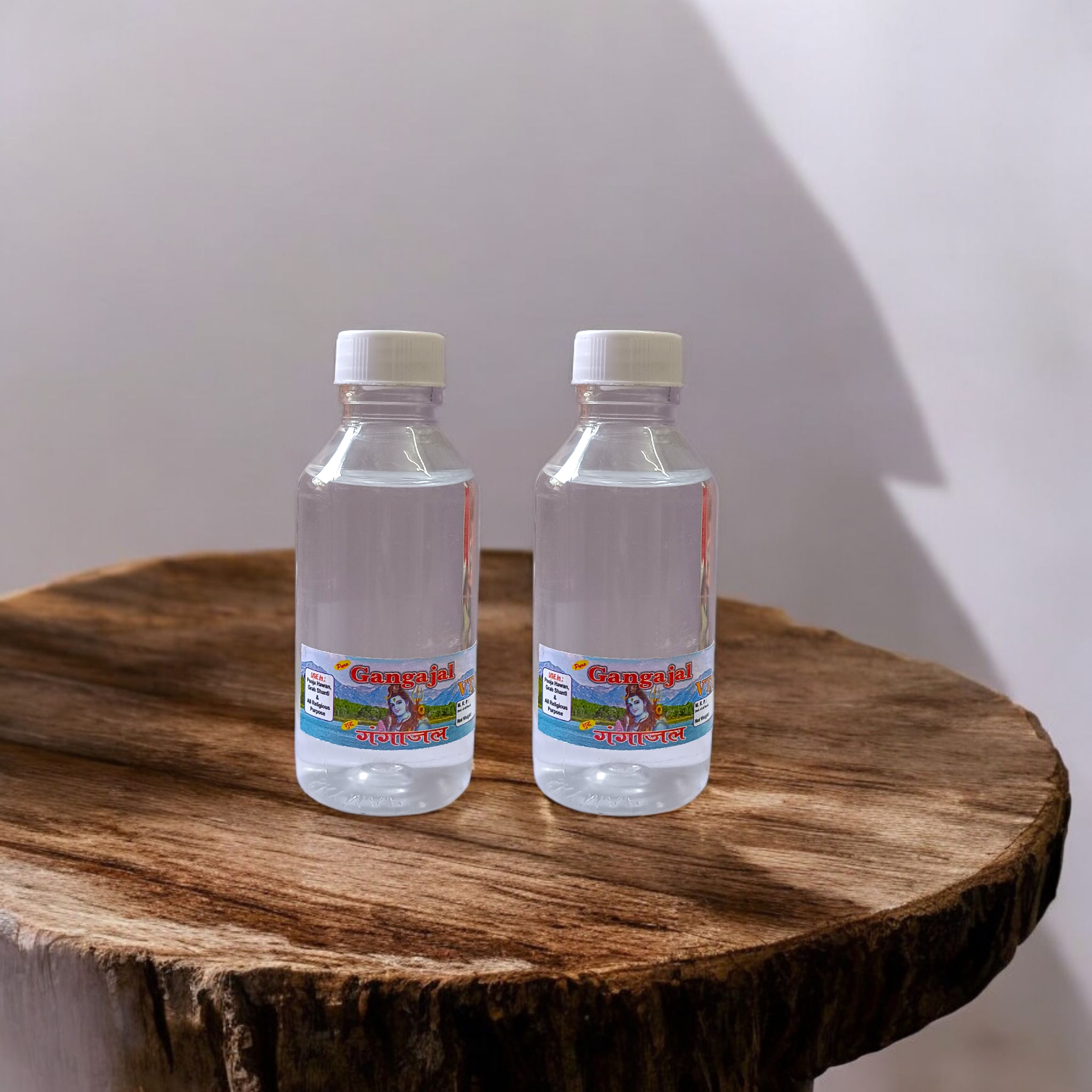 A set of two 100g bottles of Pure Gangajal Holy Water placed side by side, labeled for pooja and spiritual use