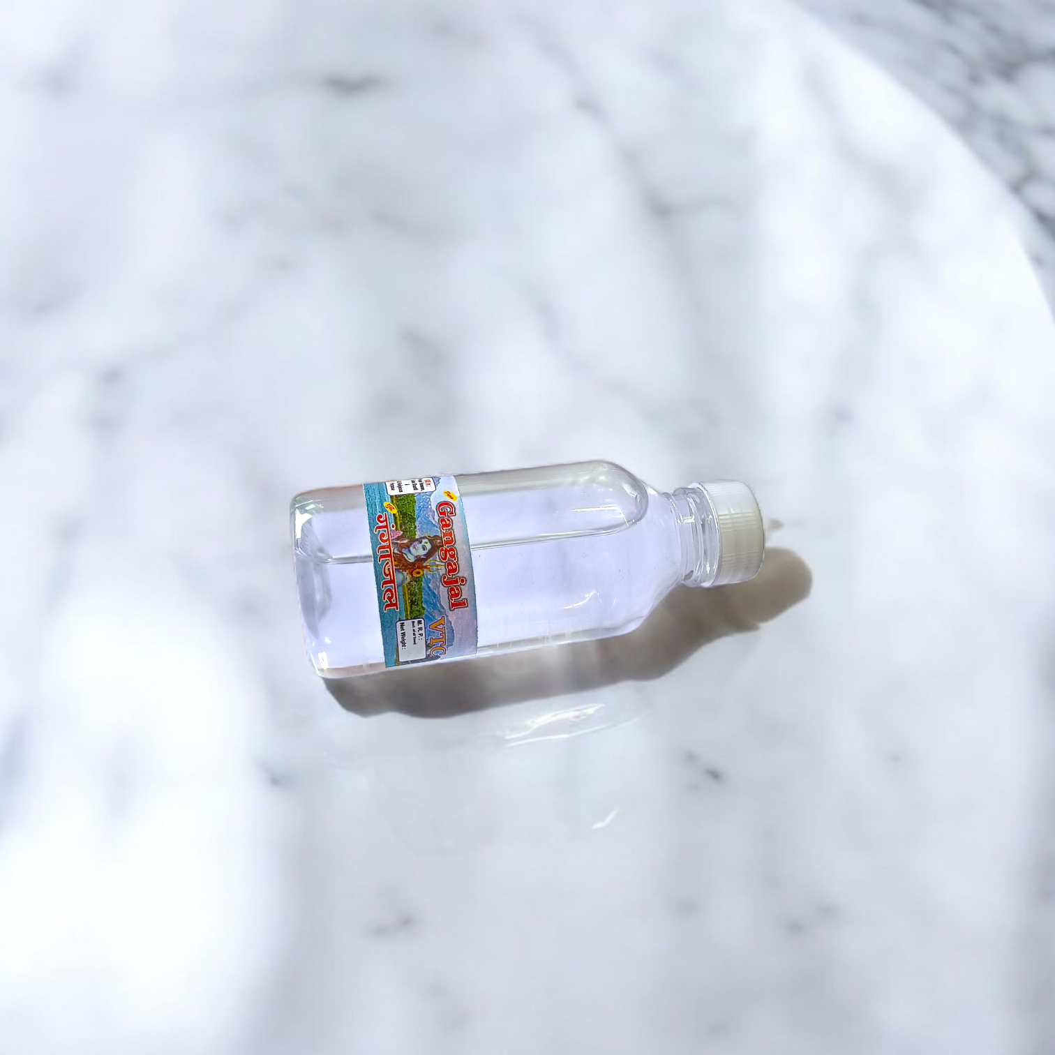 A set of two 100g bottles of Pure Gangajal Holy Water placed side by side, labeled for pooja and spiritual use