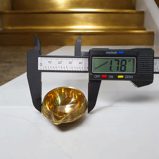 A small 2-inch brass oil lamp with a heavy base, perfect for pooja, festivals, and temple use, featuring a traditional design for stability during rituals.