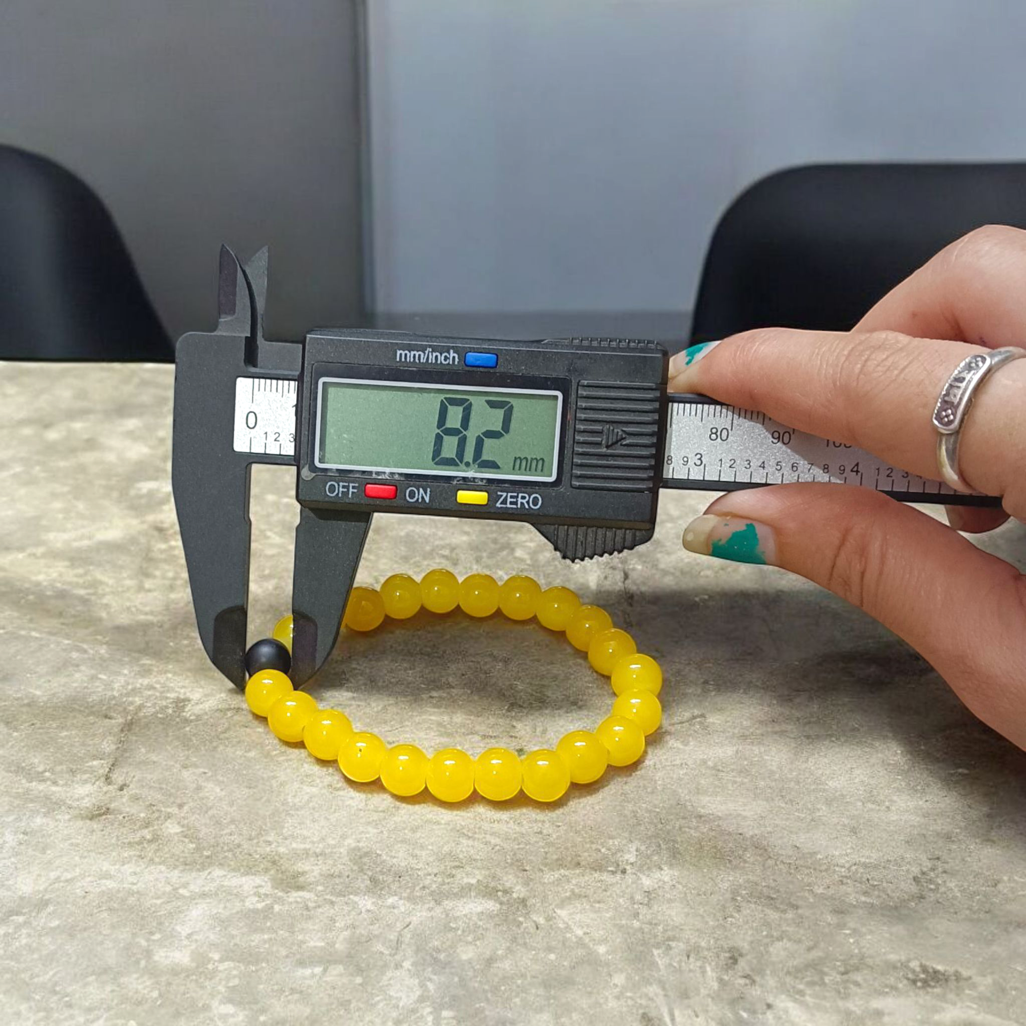 A stretchable Yellow Agate & Ebony Bracelet made with 8mm natural beads, placed neatly on a white cloth background