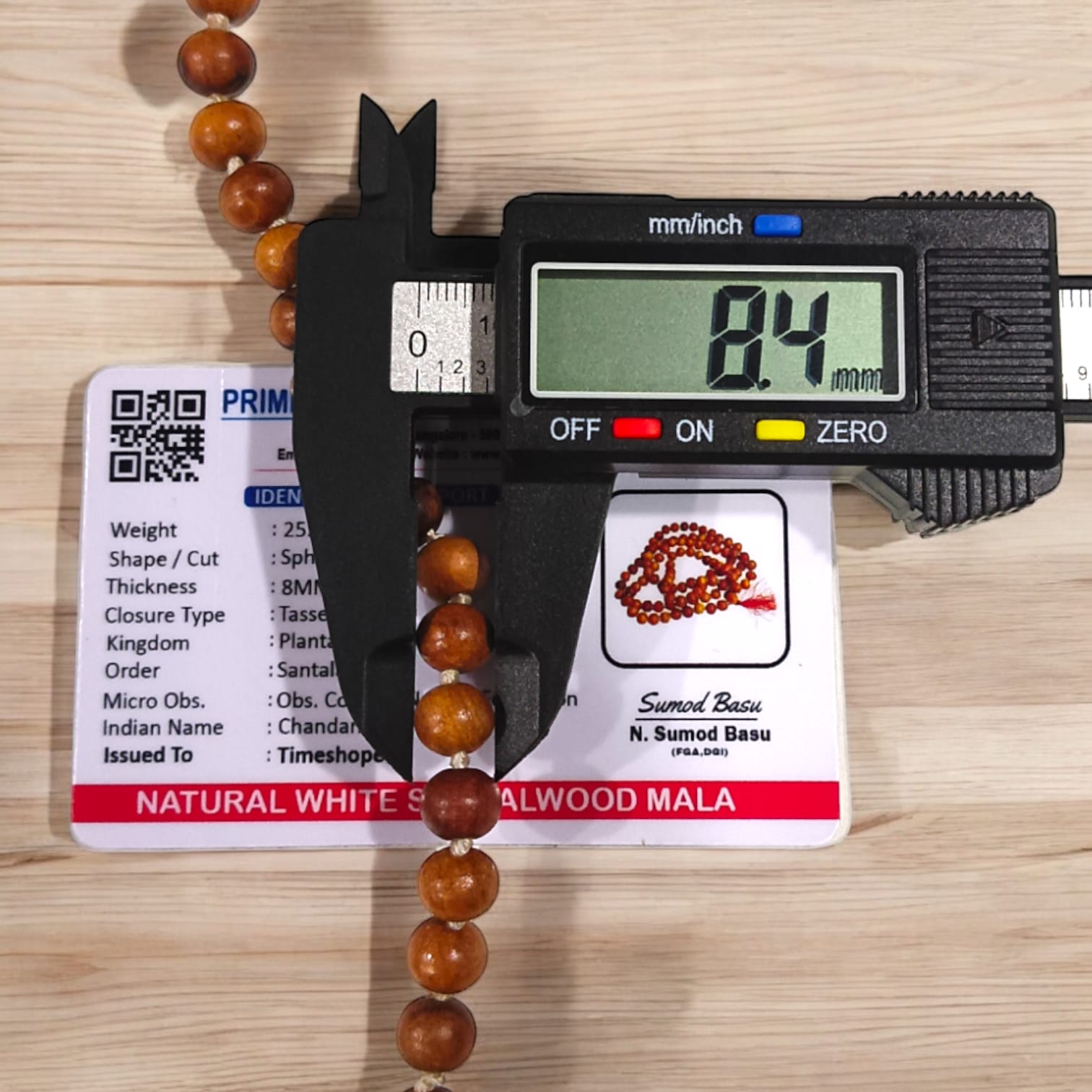 A traditional White Sandalwood Mala (Safed Chandan Mala) made with 108+1 beads, displayed with a sacred backdrop