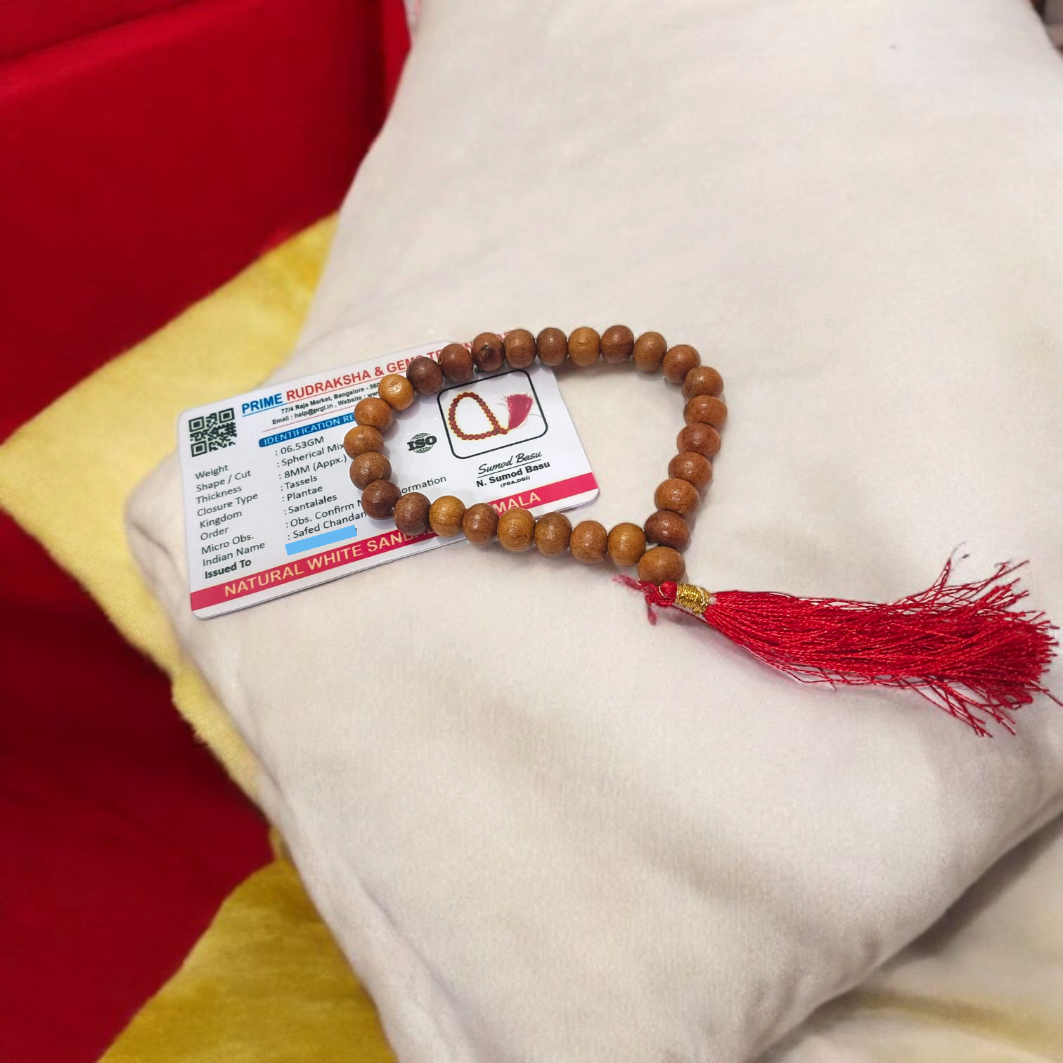 A traditional White Sandalwood Mala (Safed Chandan Mala) made with 108+1 beads, displayed with a sacred backdrop