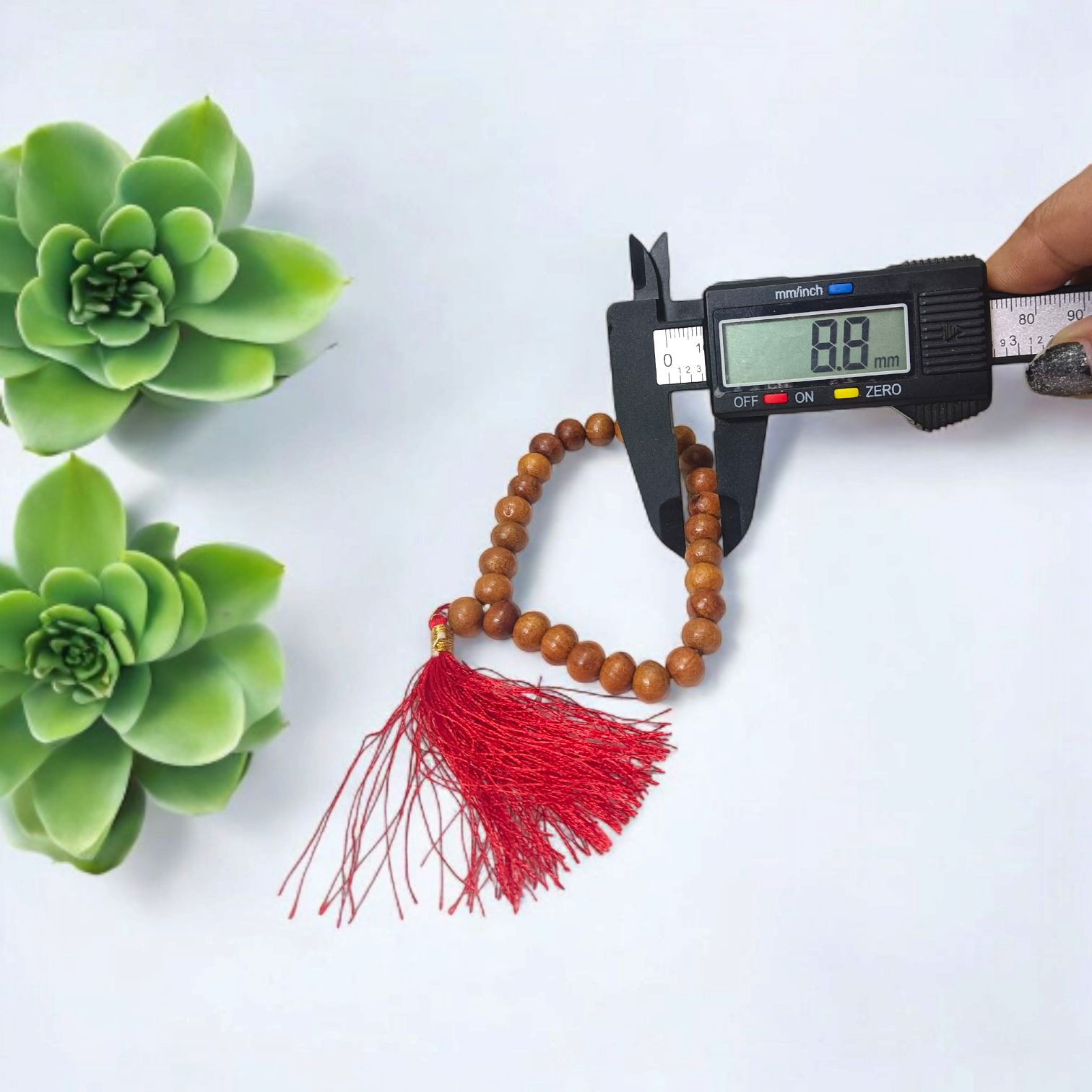 A traditional White Sandalwood Mala (Safed Chandan Mala) made with 108+1 beads, displayed with a sacred backdrop