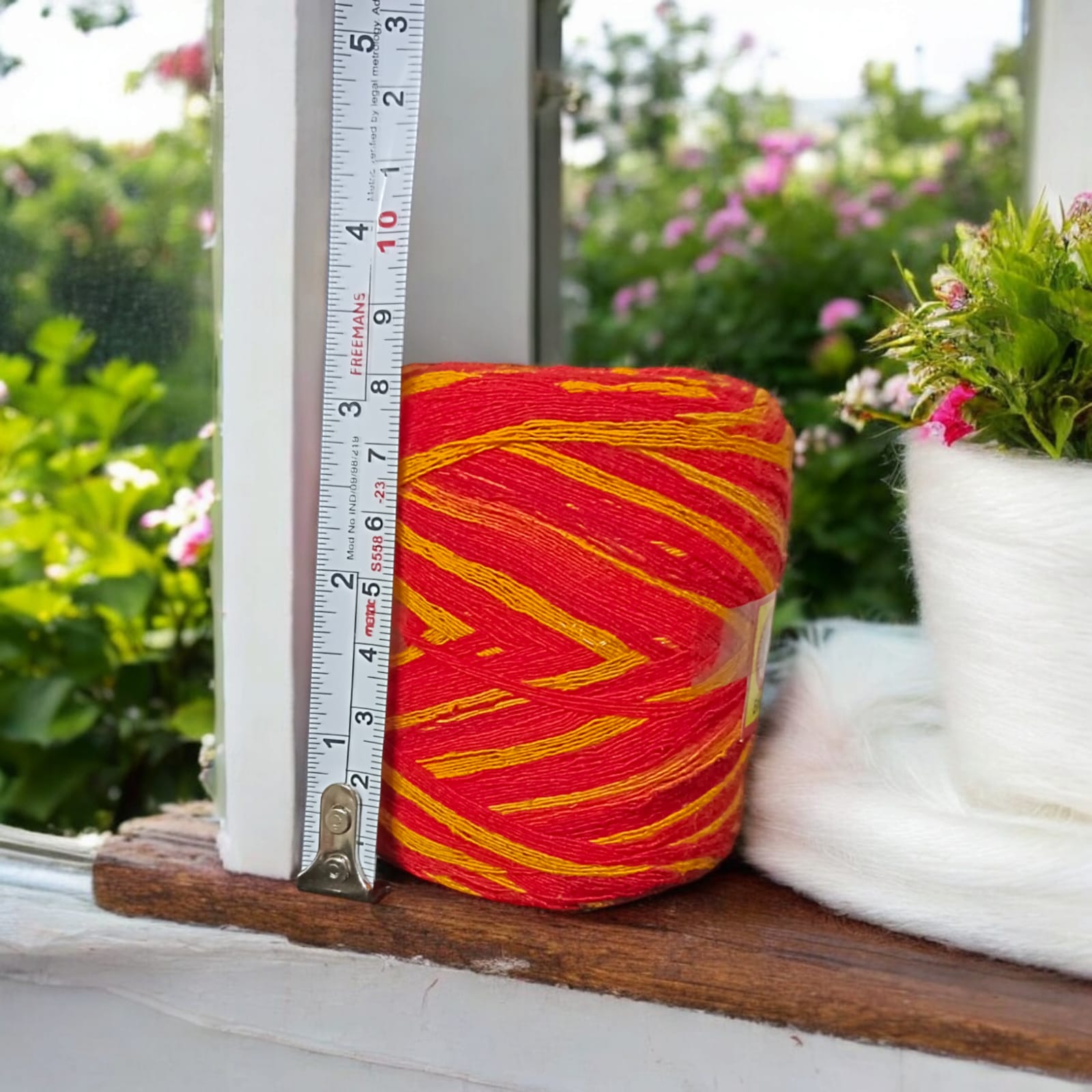 A vibrant red and yellow Moli Kalawa thread made of organic cotton, neatly coiled with extra-large length, perfect for Hindu rituals and worship ceremonies.