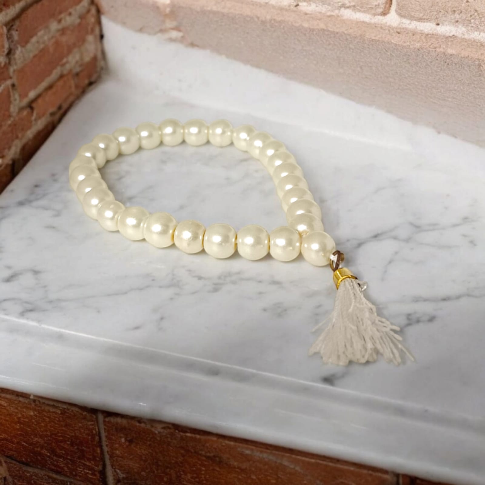 An elegant Pearl Mala featuring 27+1 original 8MM lab-certified pearls, arranged neatly for display.