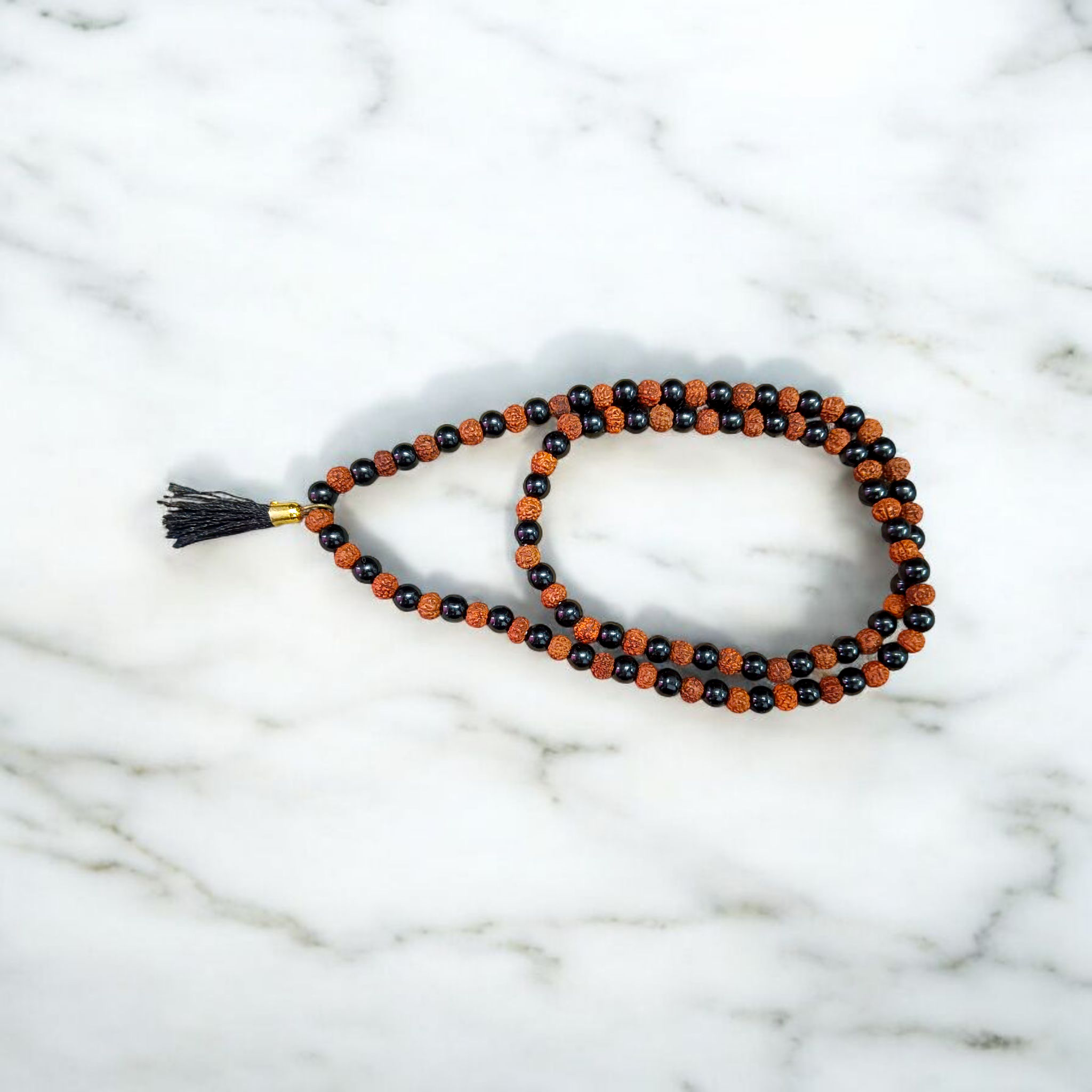 Black Agate and Rudraksha Mala with 108+1 beads, 6mm size, used for meditation and spiritual practices, displayed elegantly on a white background