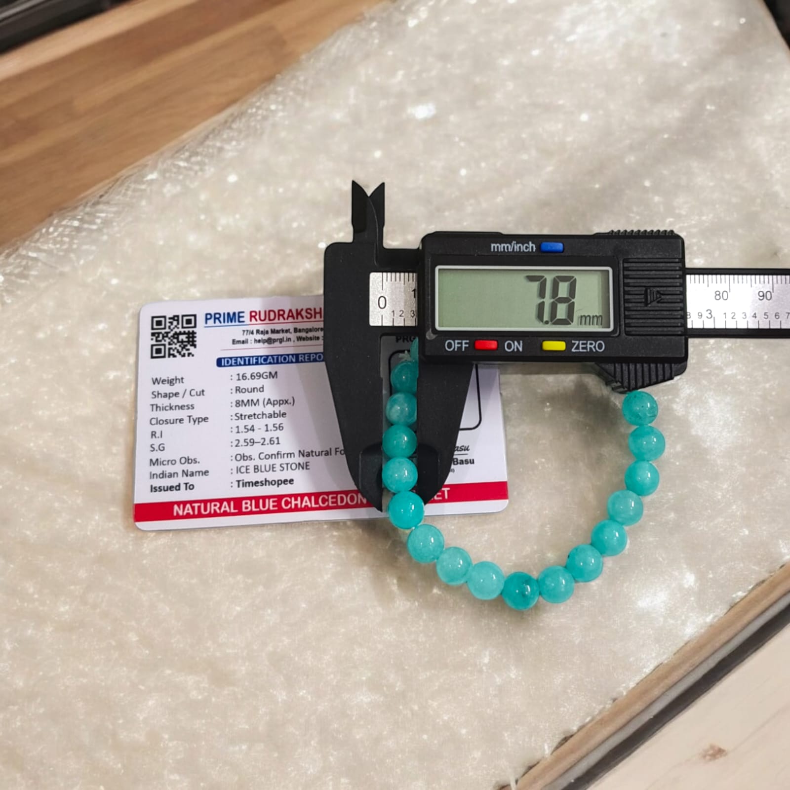 Blue Chalcedony Bracelet with lab certification, showcasing the stretchable design and soothing blue crystal.