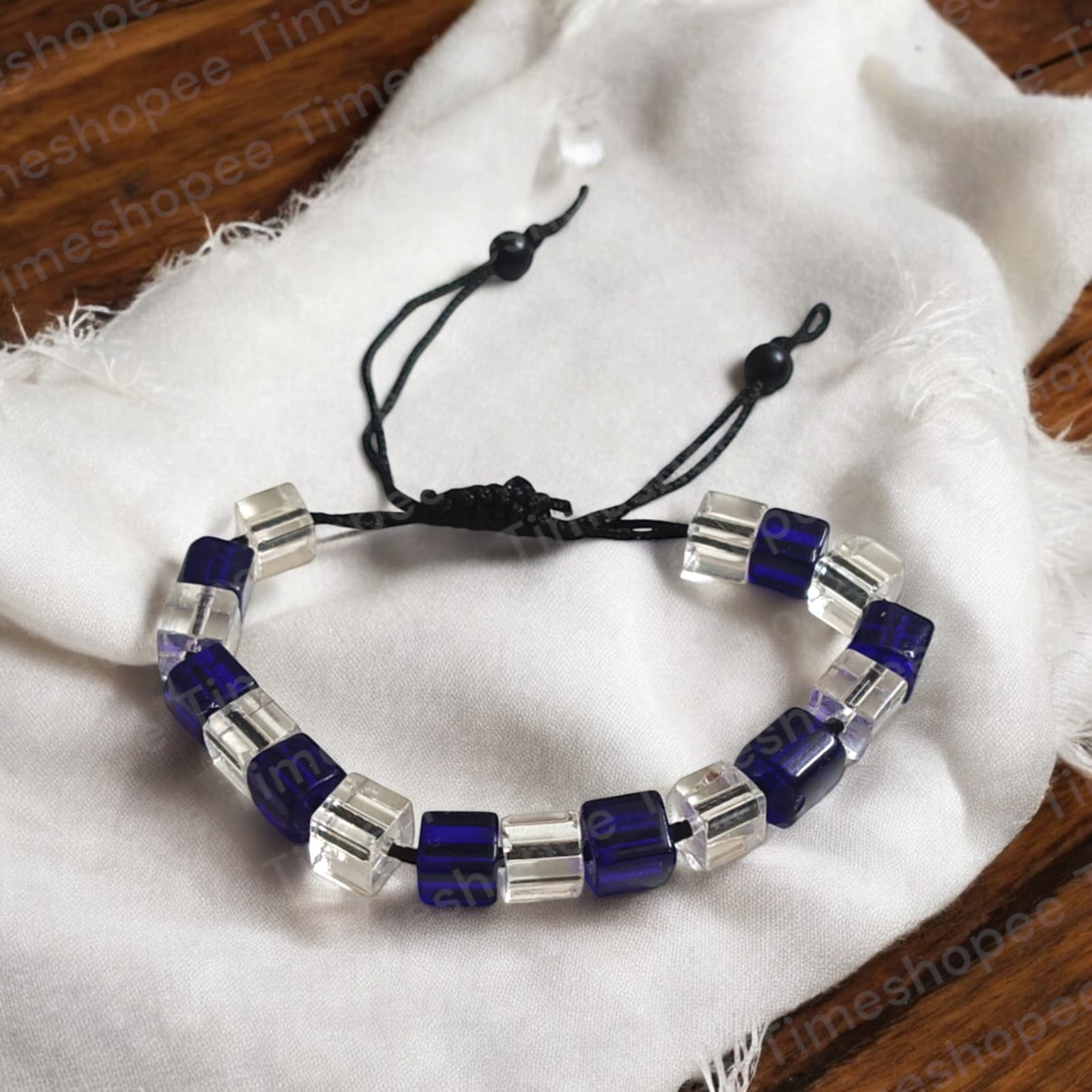 Blue and white crystal bracelet showcasing adjustable thread for a custom fit, designed to enhance personal attraction.