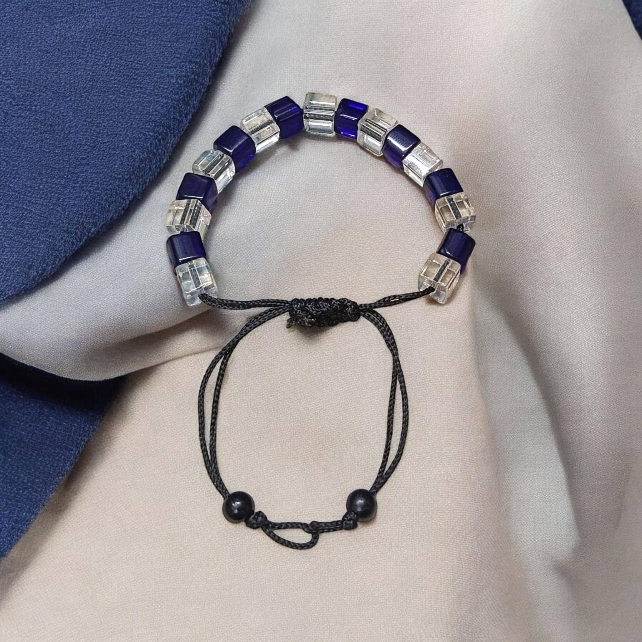 Blue and white crystal bracelet showcasing adjustable thread for a custom fit, designed to enhance personal attraction.