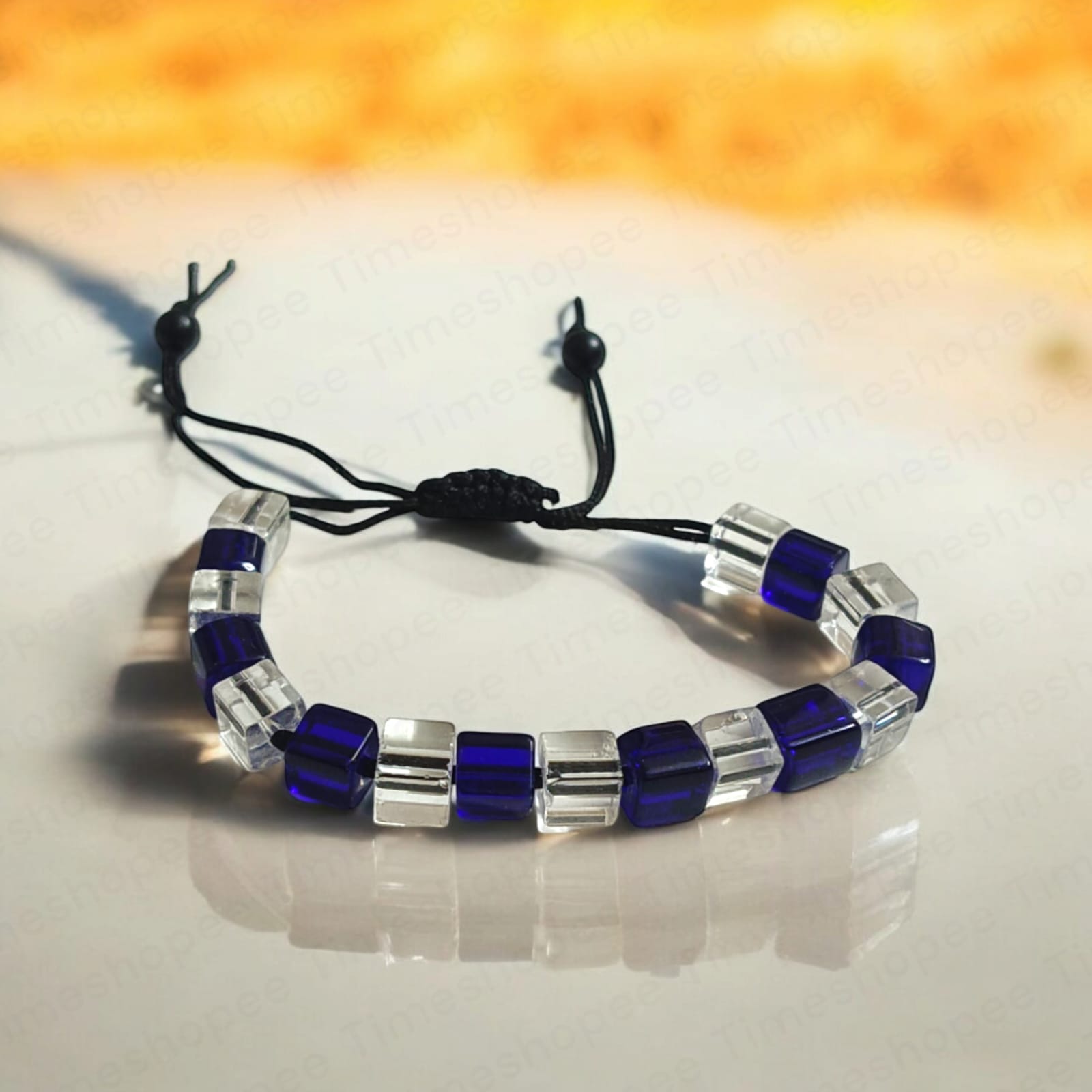 Blue and white crystal bracelet showcasing adjustable thread for a custom fit, designed to enhance personal attraction.