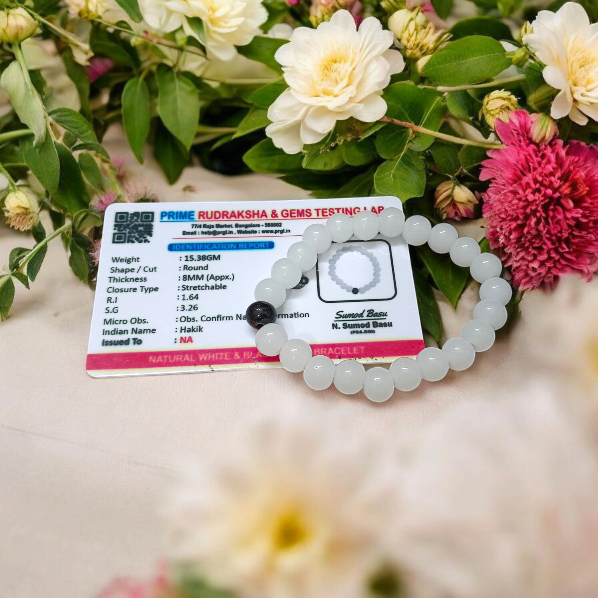 Bracelet made of 8mm natural white and black agate beads arranged on a stretchable thread, displayed on a neutral surface