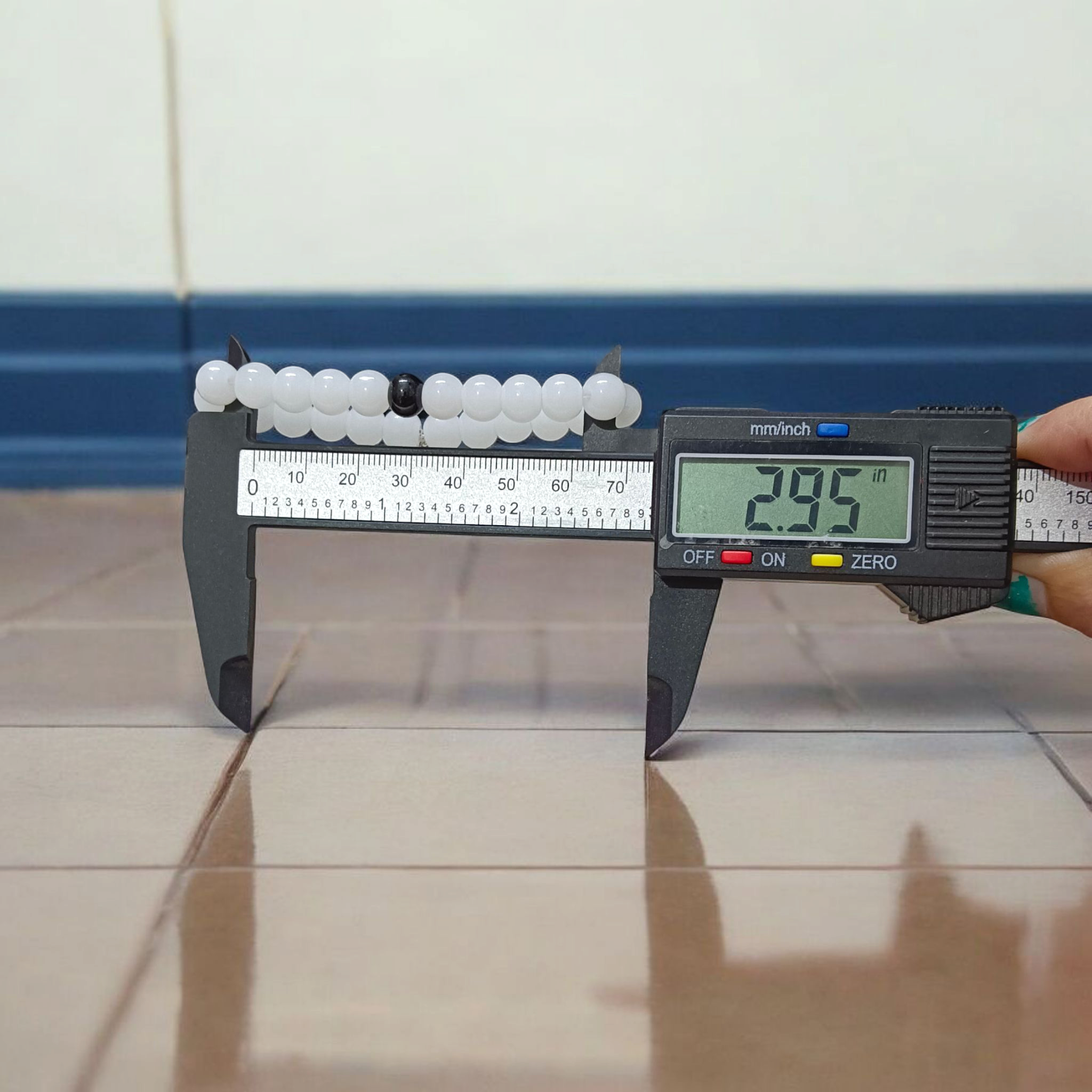 Bracelet made of 8mm natural white and black agate beads arranged on a stretchable thread, displayed on a neutral surface