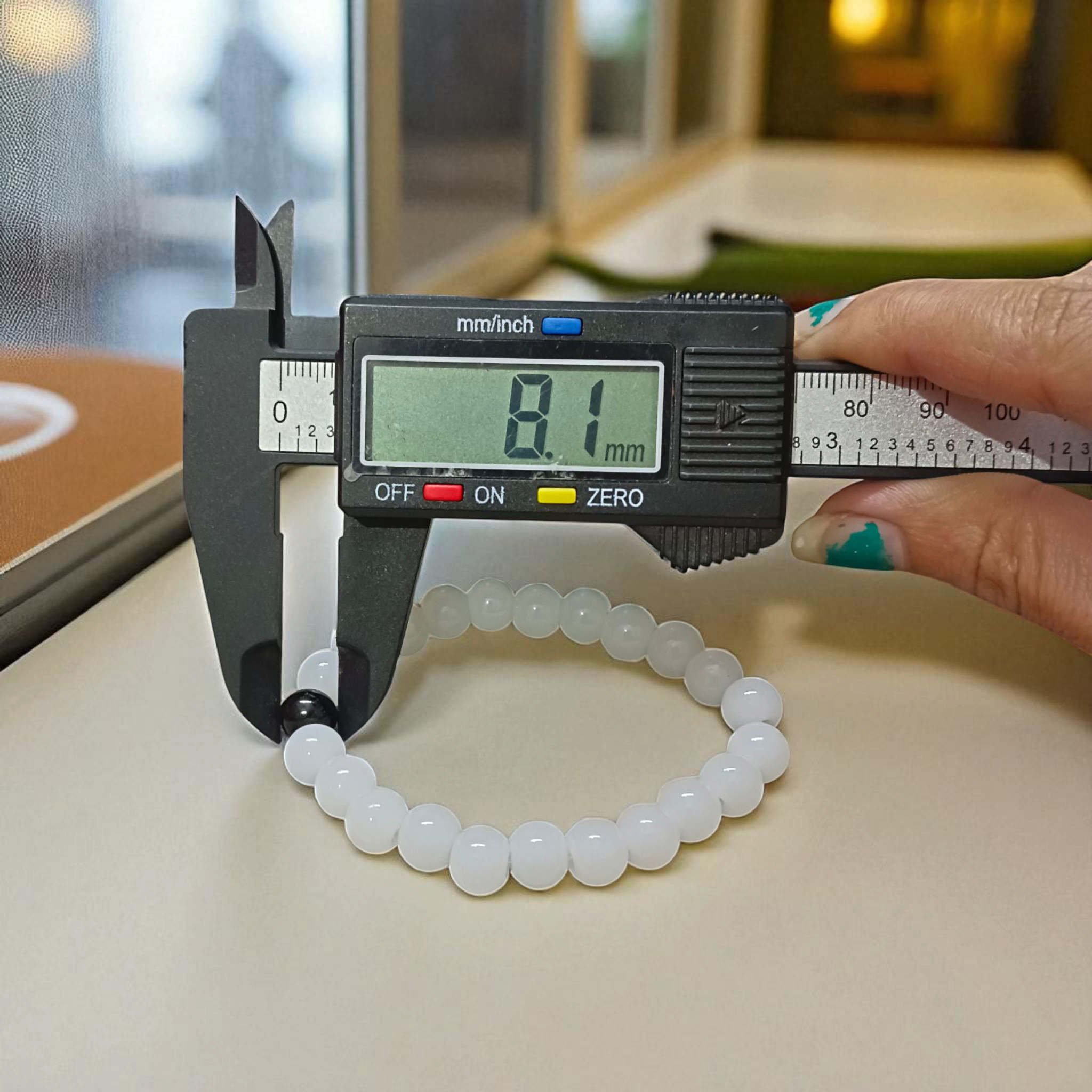 Bracelet made of 8mm natural white and black agate beads arranged on a stretchable thread, displayed on a neutral surface