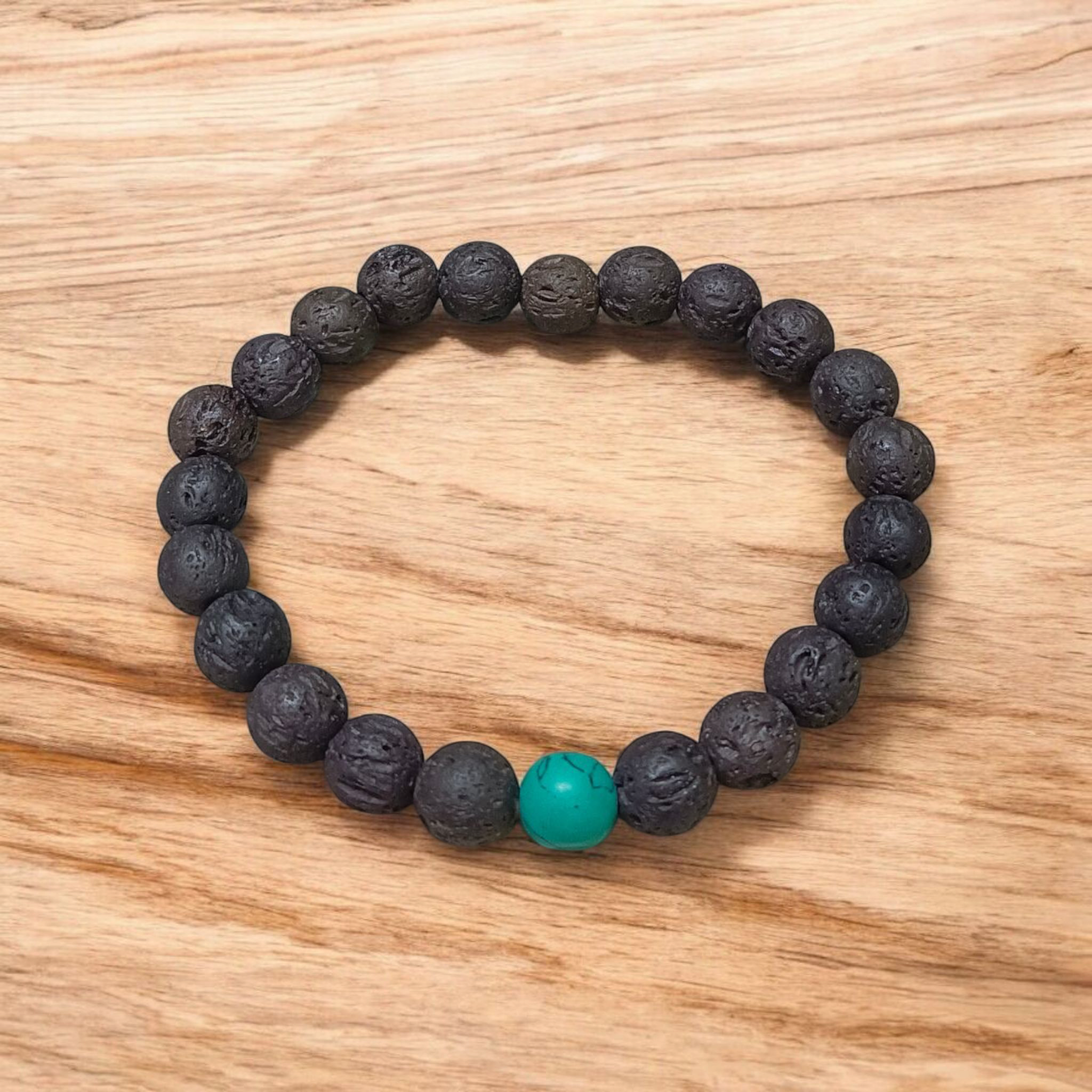 Bracelet made with 8mm black lava stones and turquoise (Firoza) beads, arranged on stretchable thread and placed on a soft neutral background