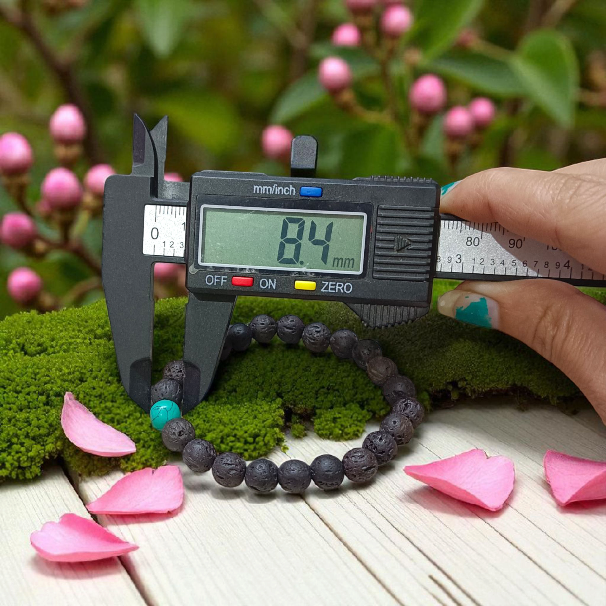 Bracelet made with 8mm black lava stones and turquoise (Firoza) beads, arranged on stretchable thread and placed on a soft neutral background