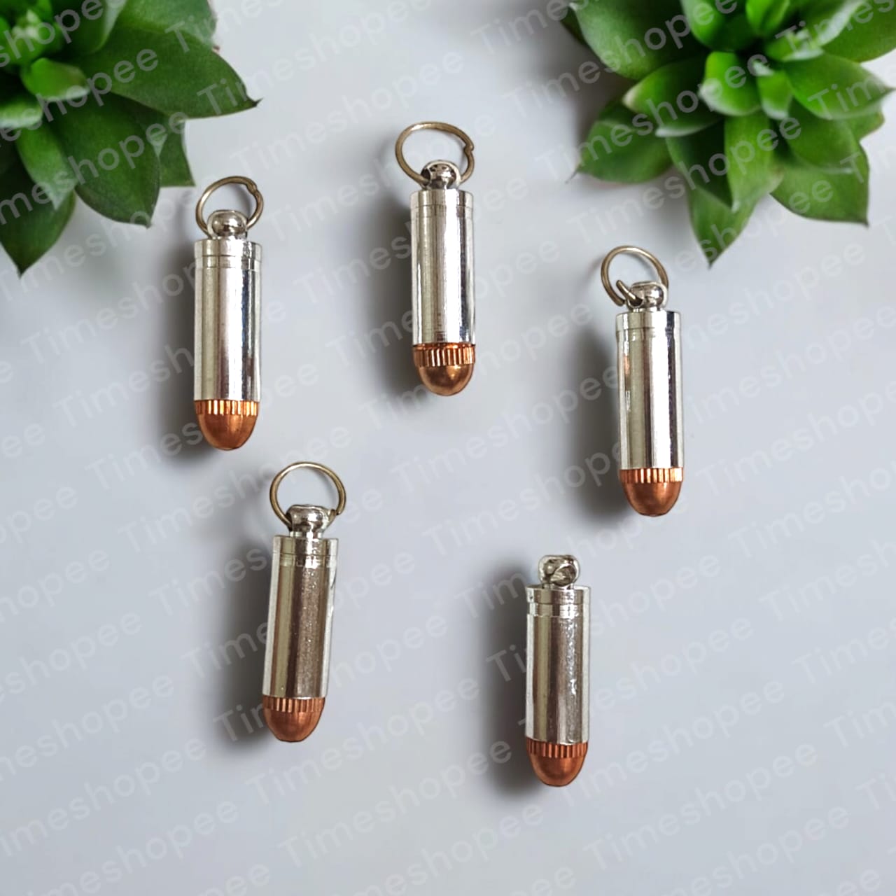 Bullet-shaped silver and copper taweez amulets with a Bhojpatra sheet, showcasing their unique design and spiritual significance.