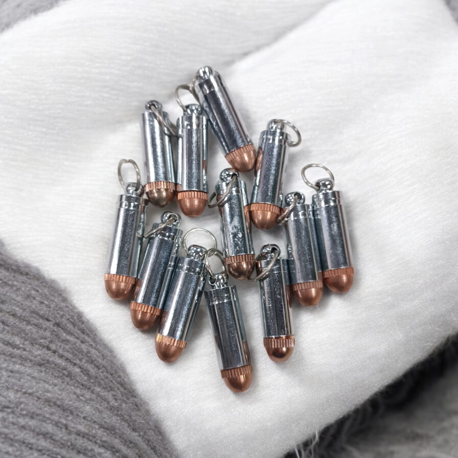 Bullet-shaped silver and copper taweez amulets with a Bhojpatra sheet, showcasing their unique design and spiritual significance.