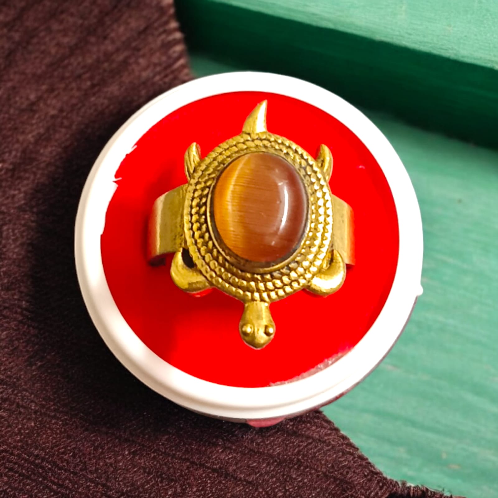 Close-up image of the Kachua Tiger Eye Ring, featuring a brown and gold Tiger Eye gemstone set in a tortoise-shaped design, made from Ashtdhatu. The ring is adjustable and unisex.