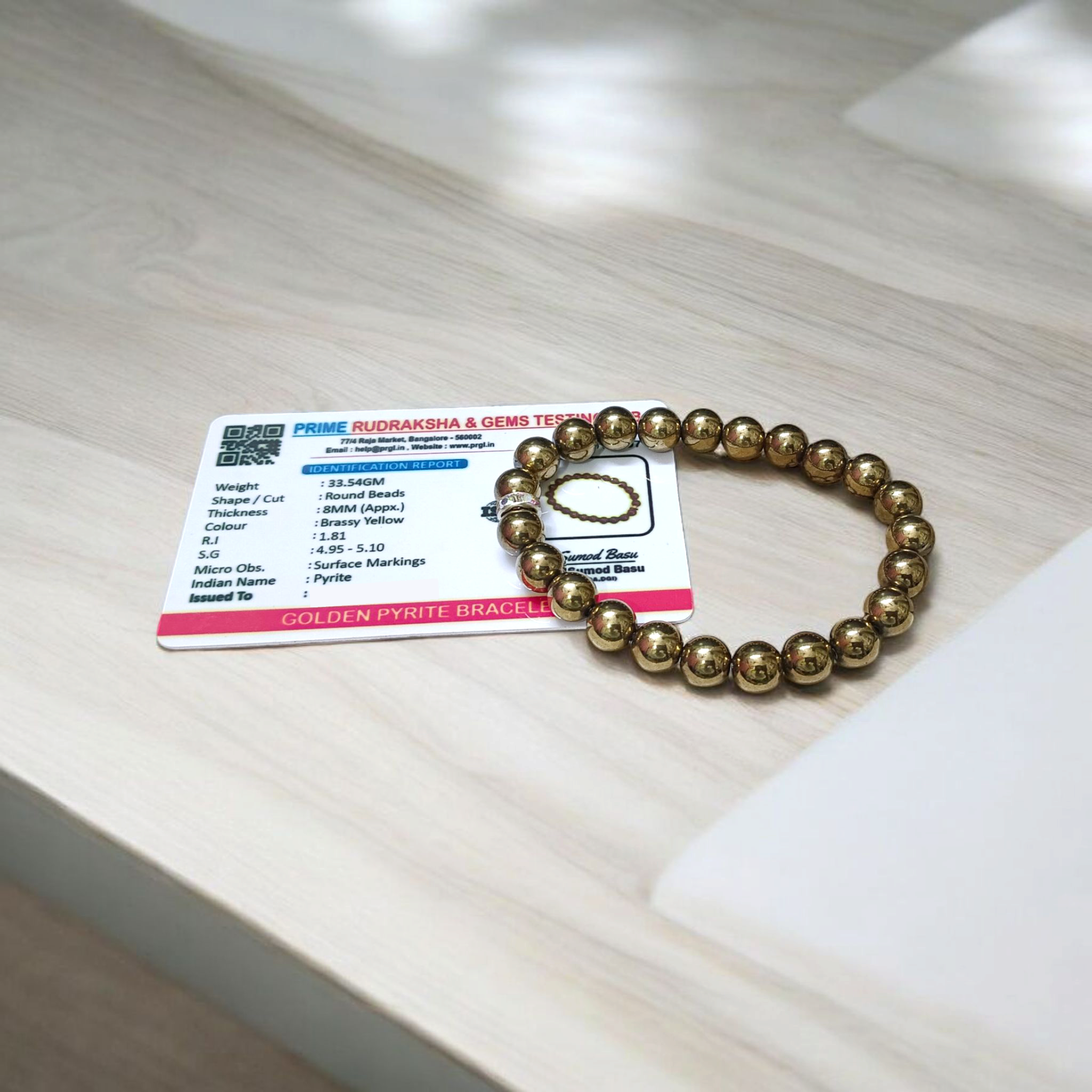 Golden Pyrite Bracelet with 8mm beads, lab-certified, displayed in a circular arrangement with elegant packaging