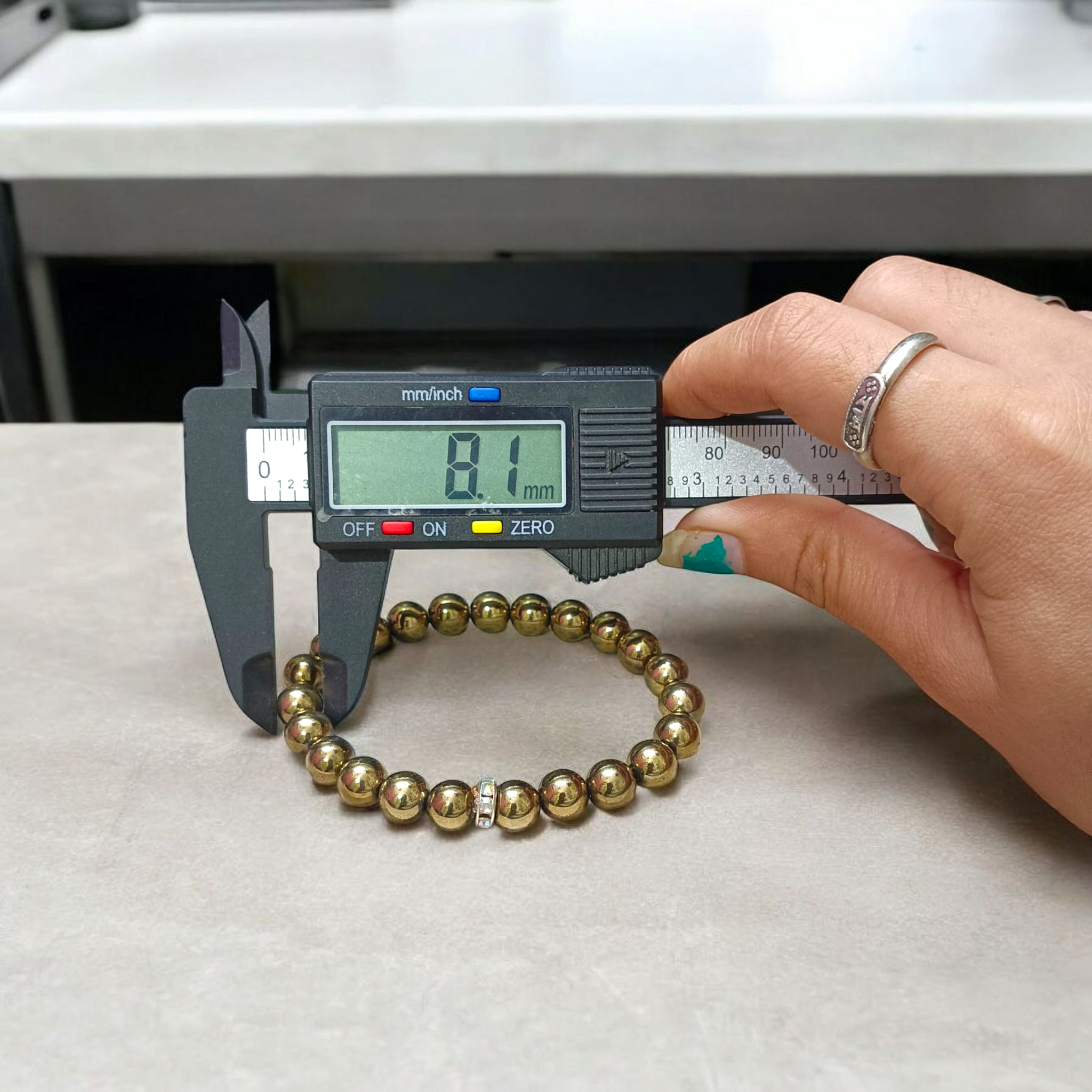 Golden Pyrite Bracelet with 8mm beads, lab-certified, displayed in a circular arrangement with elegant packaging