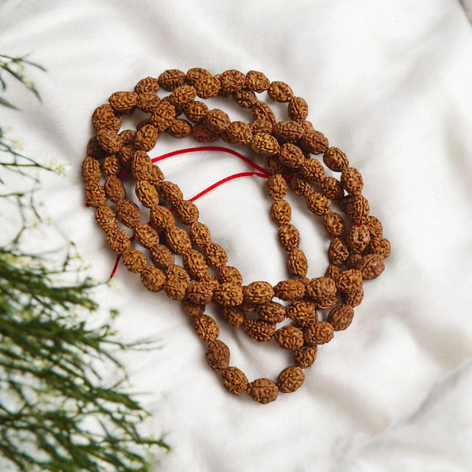 High-quality image of 3 Mukhi Rudraksha Mala in 27+1 and 108+1 bead variants, handcrafted and spiritually energized, displayed with a clean spiritual background