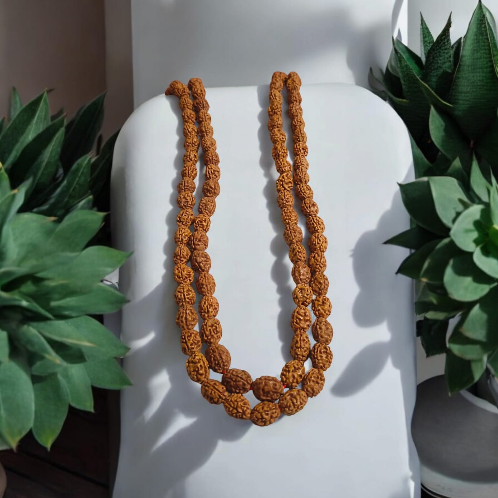 High-quality image of 3 Mukhi Rudraksha Mala in 27+1 and 108+1 bead variants, handcrafted and spiritually energized, displayed with a clean spiritual background.