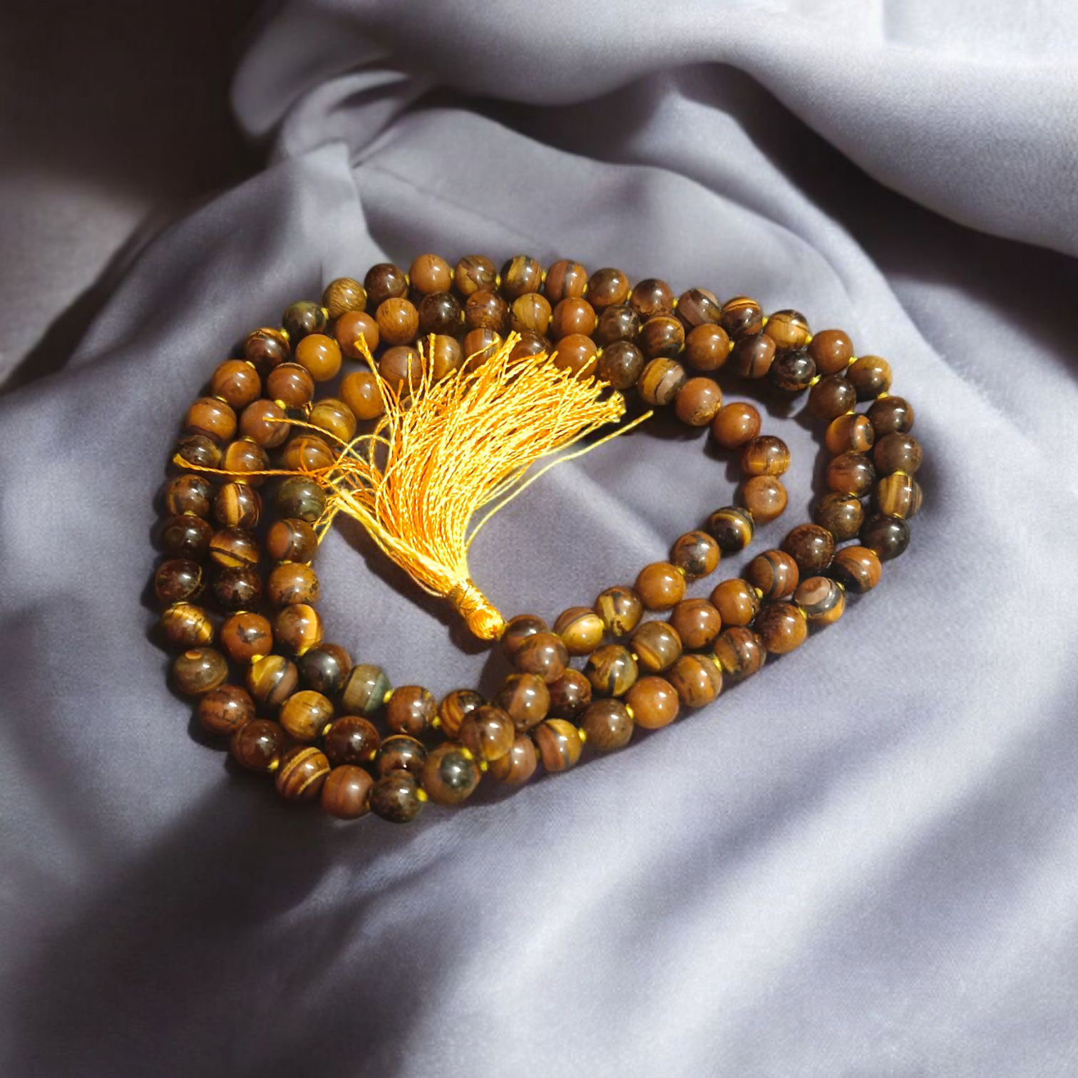 High-quality image of Tiger Eye Mala with natural golden-brown stone beads arranged in a traditional mala style